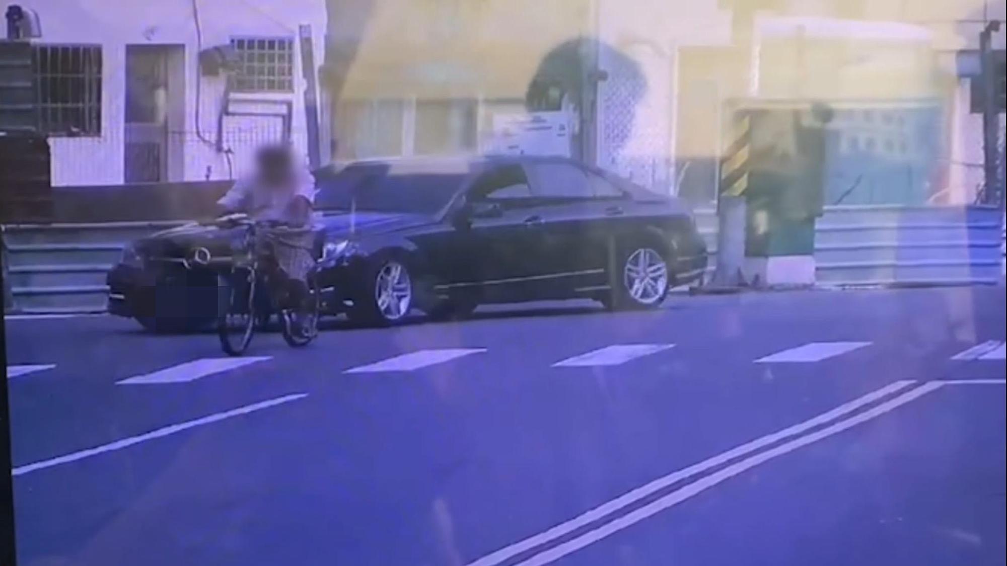  監視器畫面中，賓士車僅因質疑腳踏車違規，駕駛就暴打騎車的老人。（翻攝畫面）