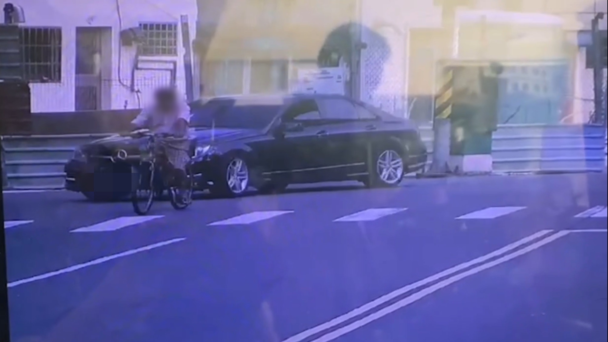  監視器畫面中，賓士車僅因質疑腳踏車違規，駕駛就暴打騎車的老人。（翻攝畫面）