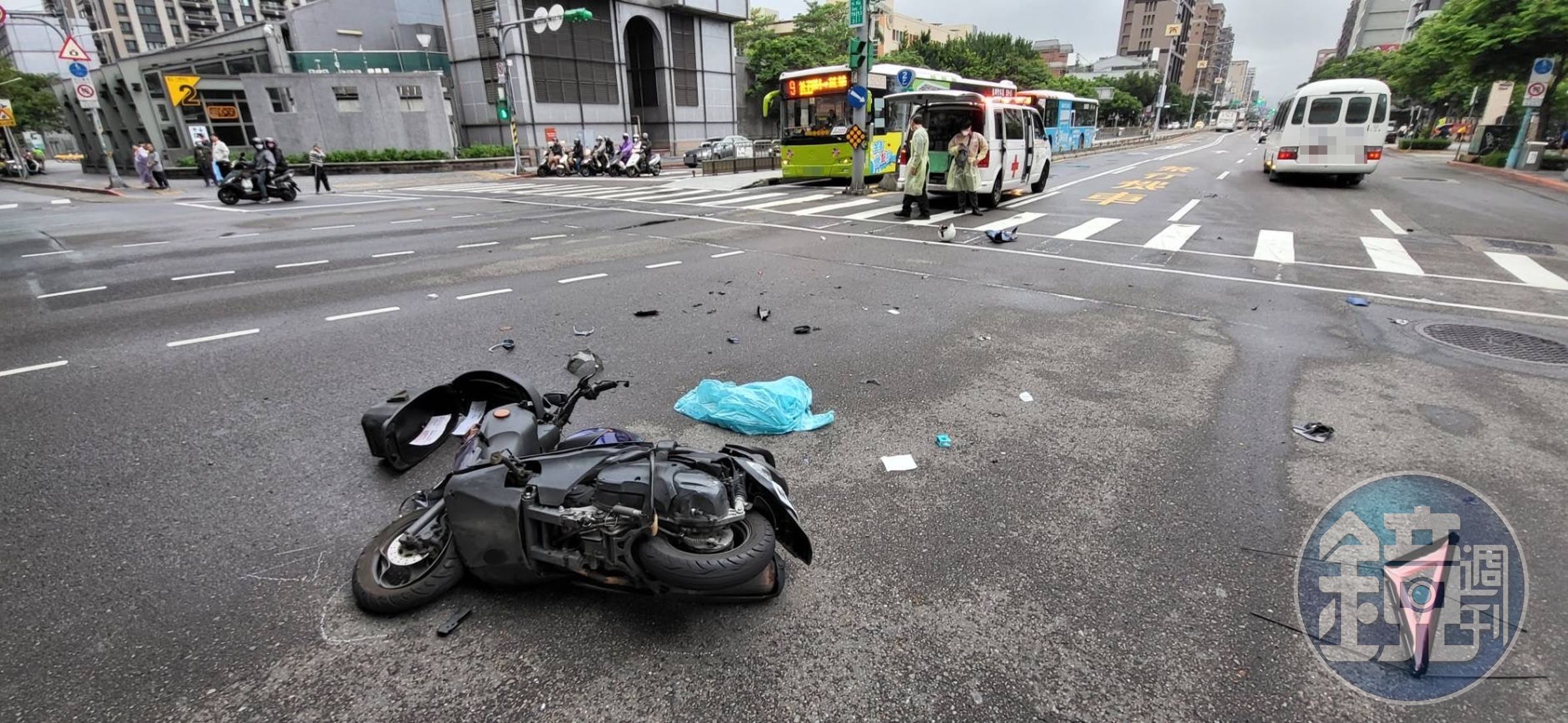 機車騎士在路口攔腰撞上救護車,造成機車解體零件四散。(翻攝畫面)
