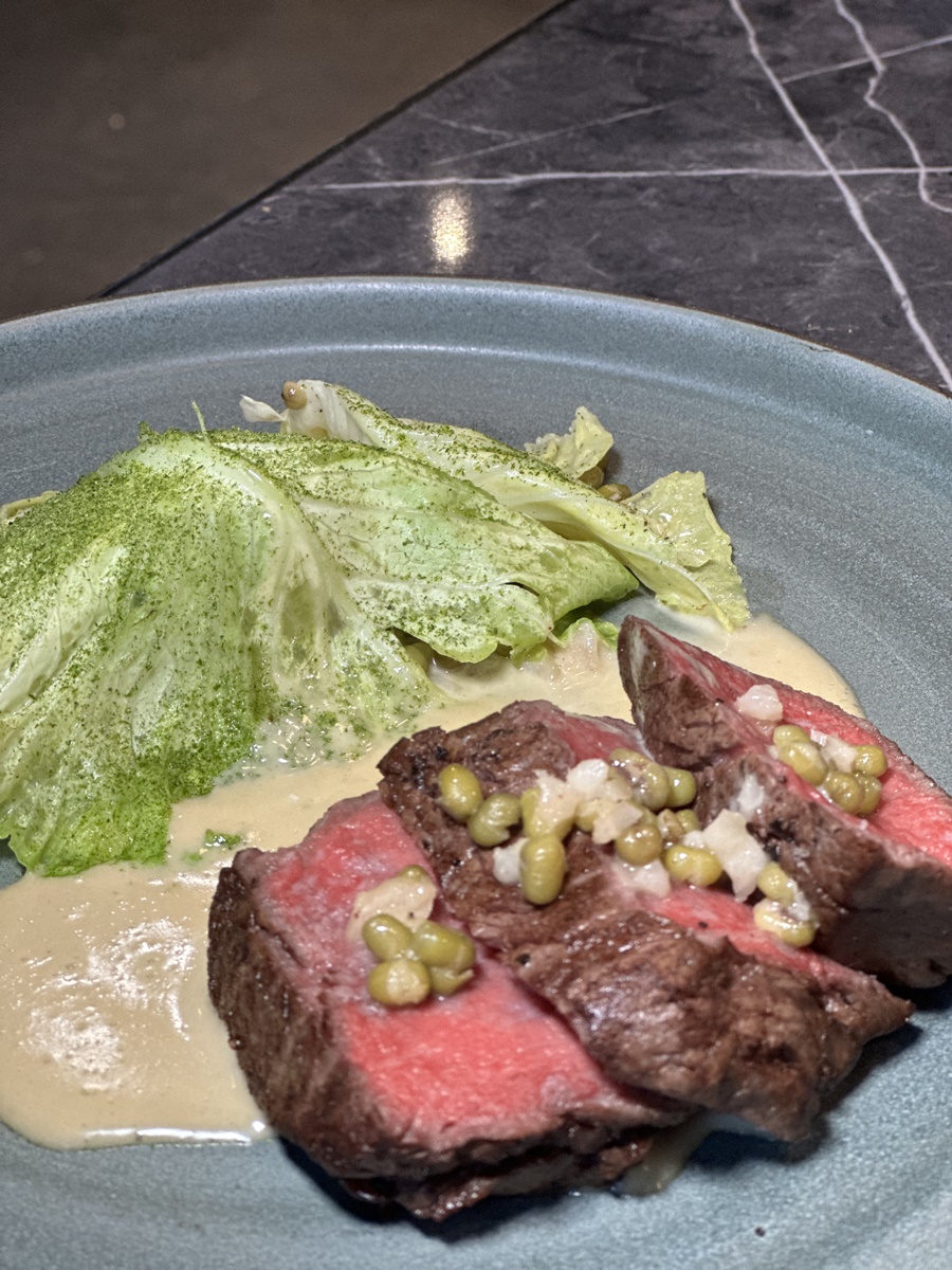 「美國安格斯牛菲力」以傳統客家菜餚「菜脯綠豆炒牛肉」作食材的玩味與延伸，搭配上高麗菜苗與蒜苗粉，演繹家常菜的變化。（1,380元／份）