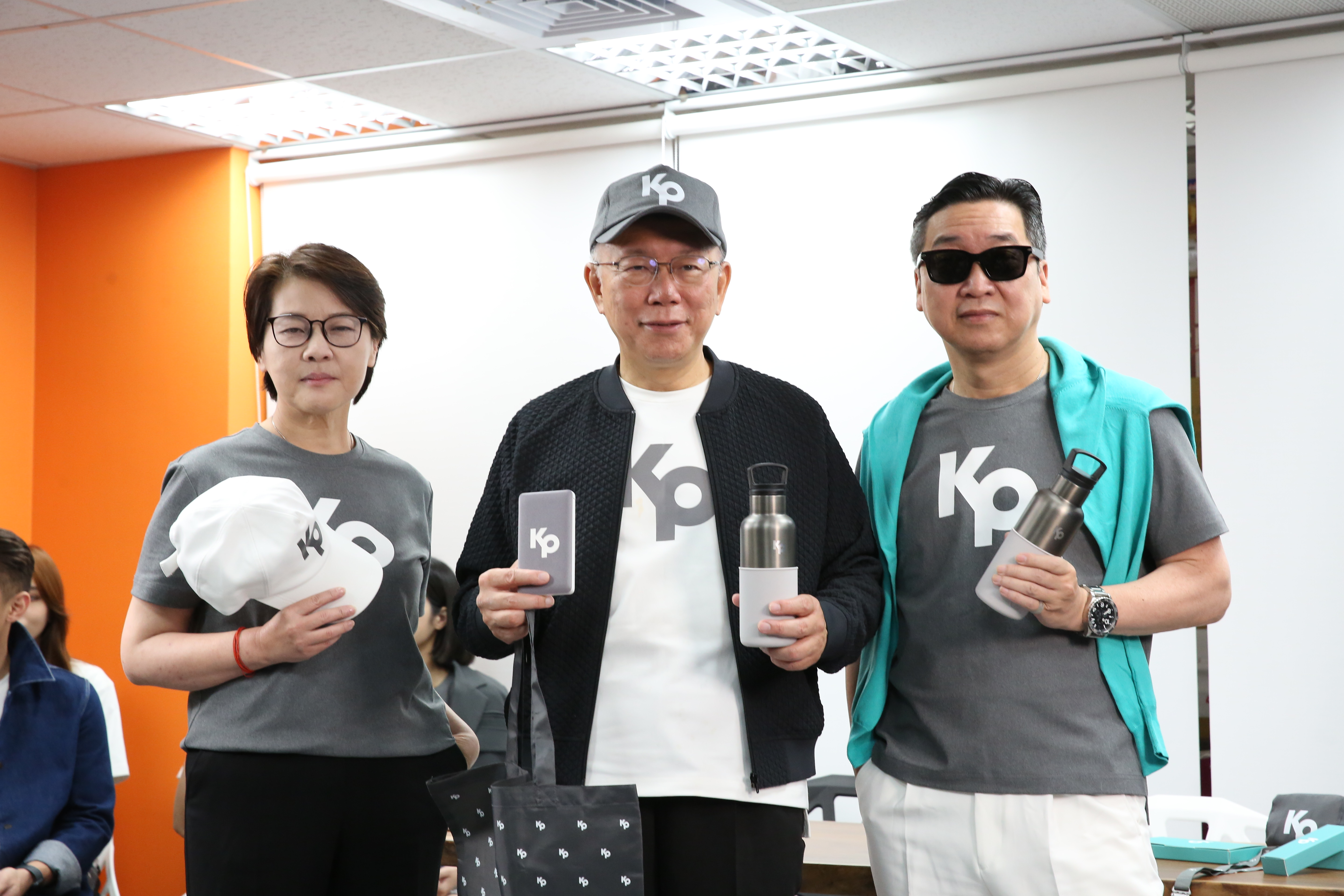 柯文哲（中）今舉辦競選募款集資「回饋小物」開箱記者會，其中鴨舌帽可透過1,450點兌換。