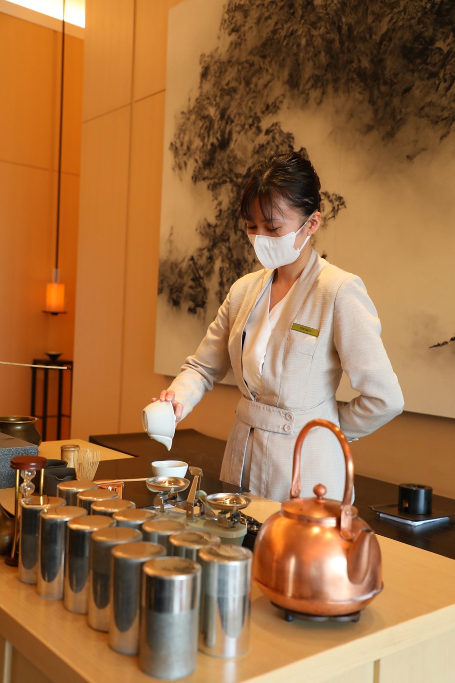 服務人員為享用下午茶的顧客沏茶。