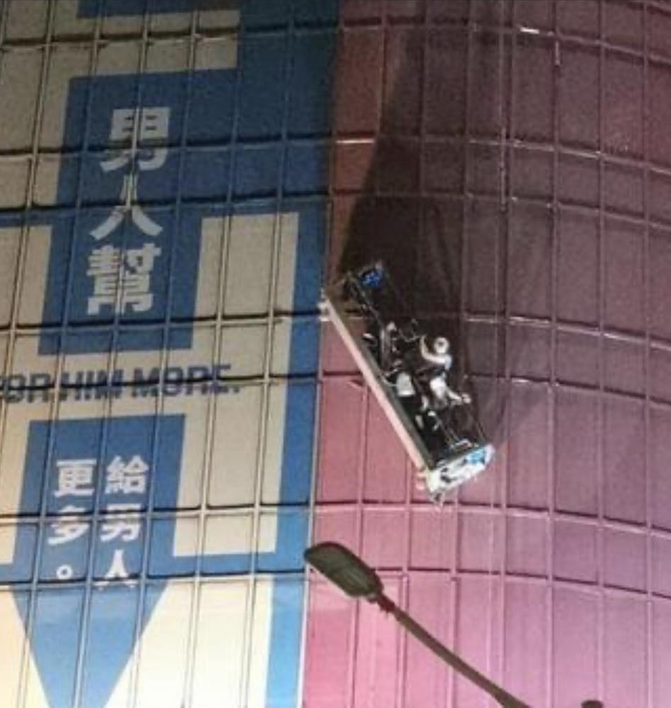 北市環亞大樓1日深夜發生工安意外，3名工人在外牆施工時發生吊籠傾斜，受困在空中險象環生。（翻攝臉書「●【爆料公社】●」）