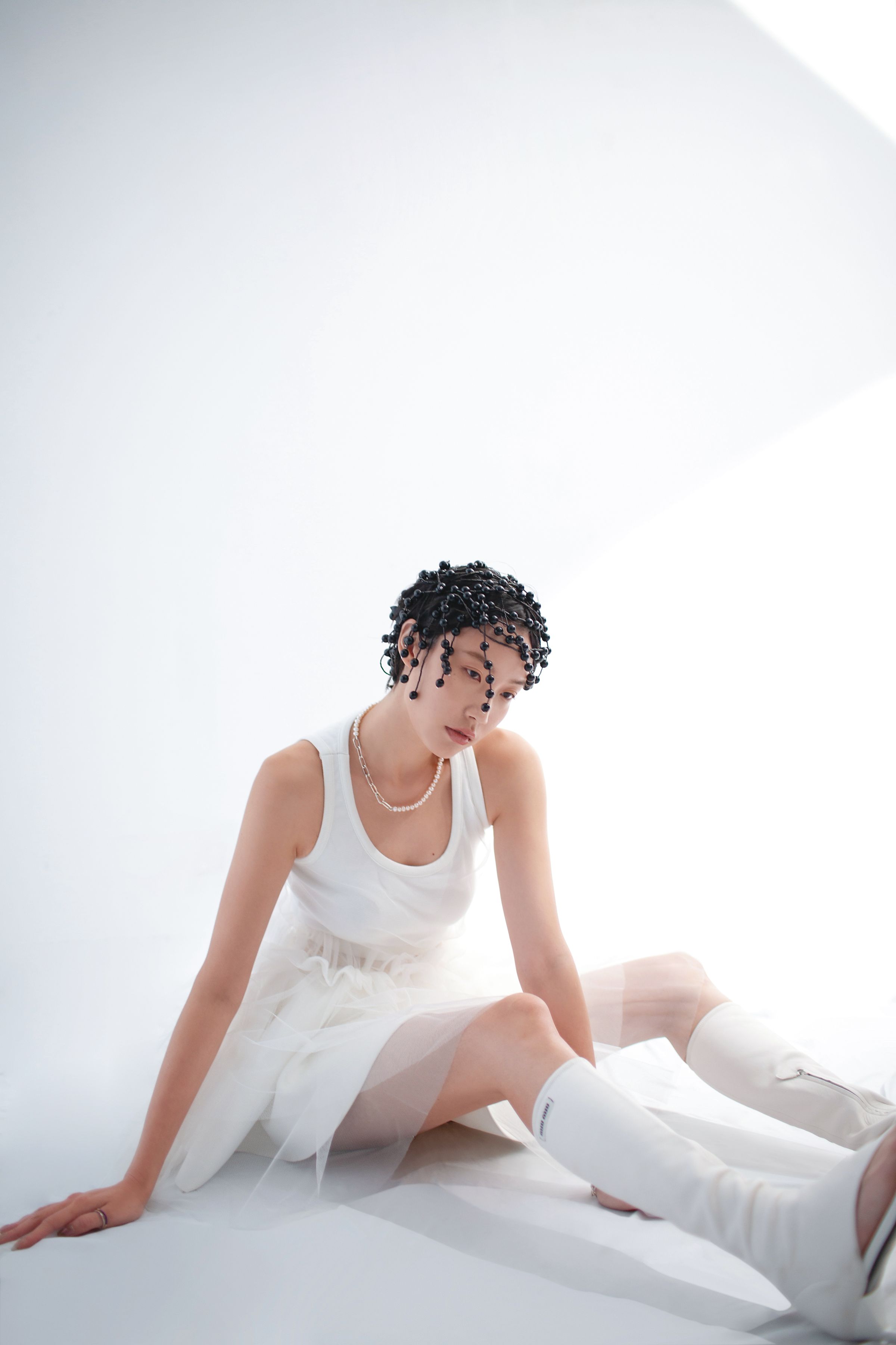 薄紗拼接洋裝NT$18,800 by MSGM；白色針織短裙NT$83,000 by LOEWE；彈性納帕軟皮夾趾長靴NT$70,000 by MIU MIU；黑色珠飾髮飾NT$176,900 by GUCCI；Pandora ME系列人工淡水養殖珍珠項鍊NT$9,980 by PANDORA；Pandora ME系列密鑲寶石配紅色琺瑯戒指NT$1,580 by PANDORA；Pandora ME系列密鑲寶石配藍色琺瑯戒指NT$2,480 by PANDORA。