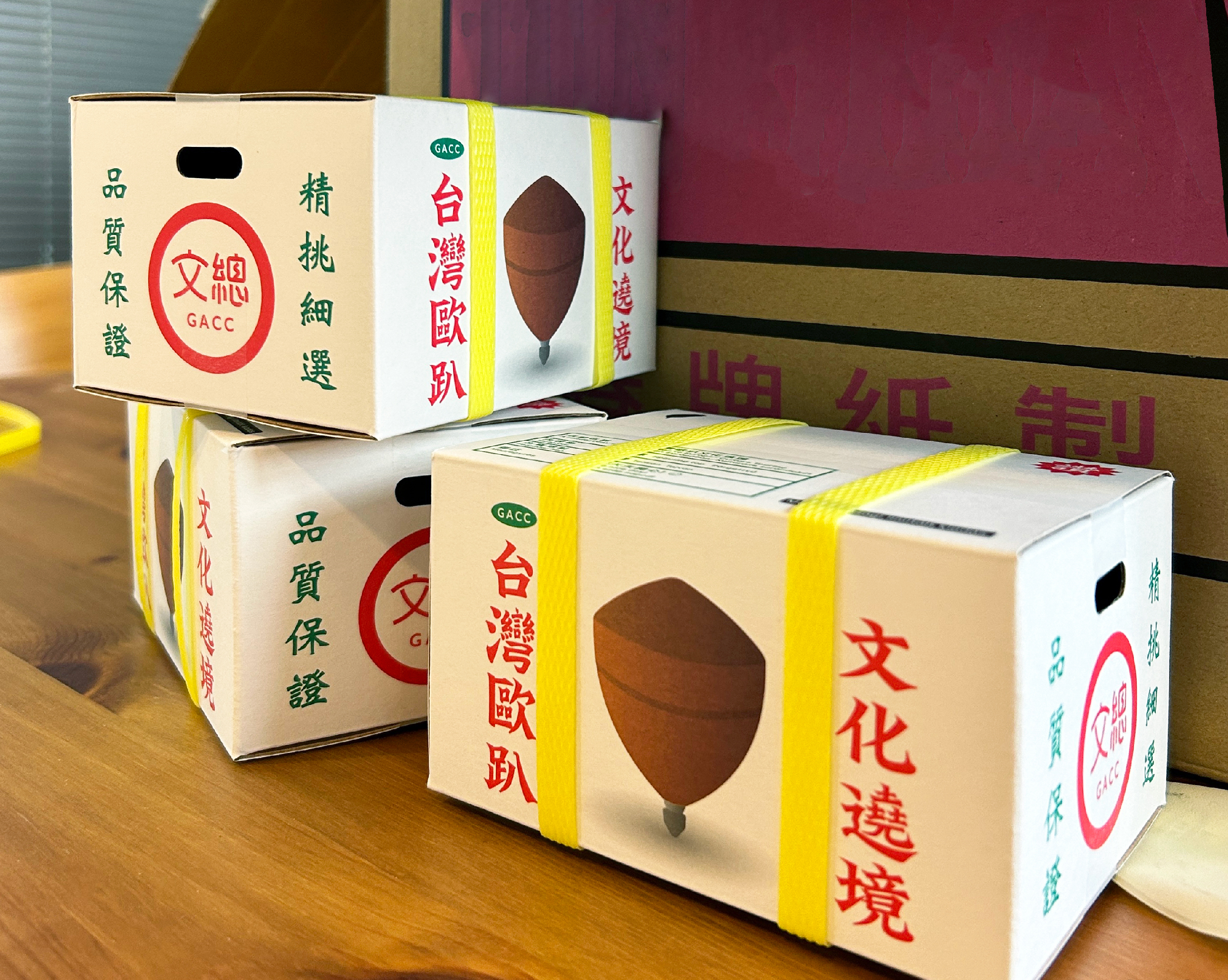 以台灣常見的紅白配色水果箱，作為陀螺的外包裝，配上黃色封箱繩與產品標示等設計，充滿濃濃台味。（文化總會提供）
