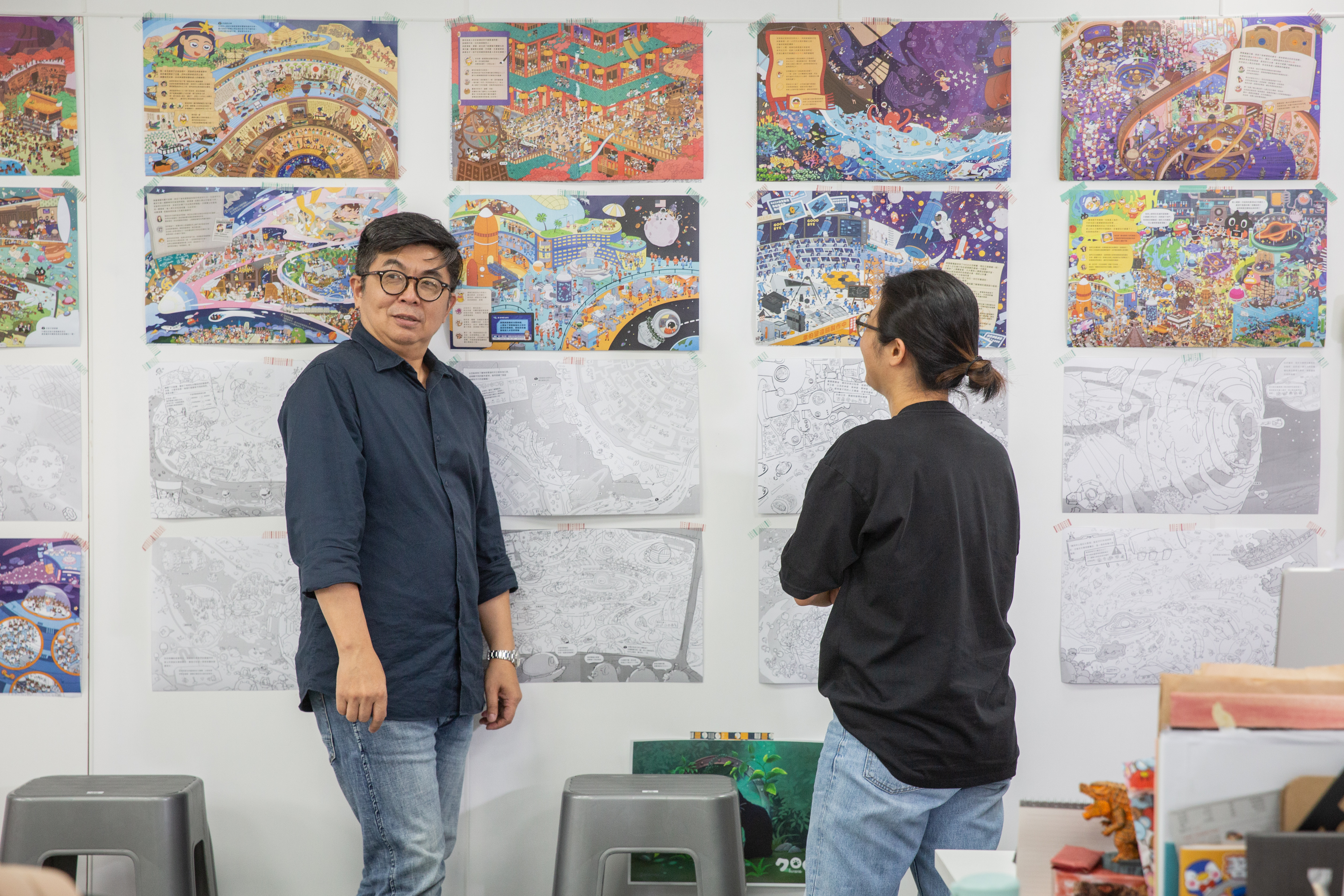 高景星（左）與同仁討論今年將出版的Kuroro找找書，一張圖都由多人合力完成。