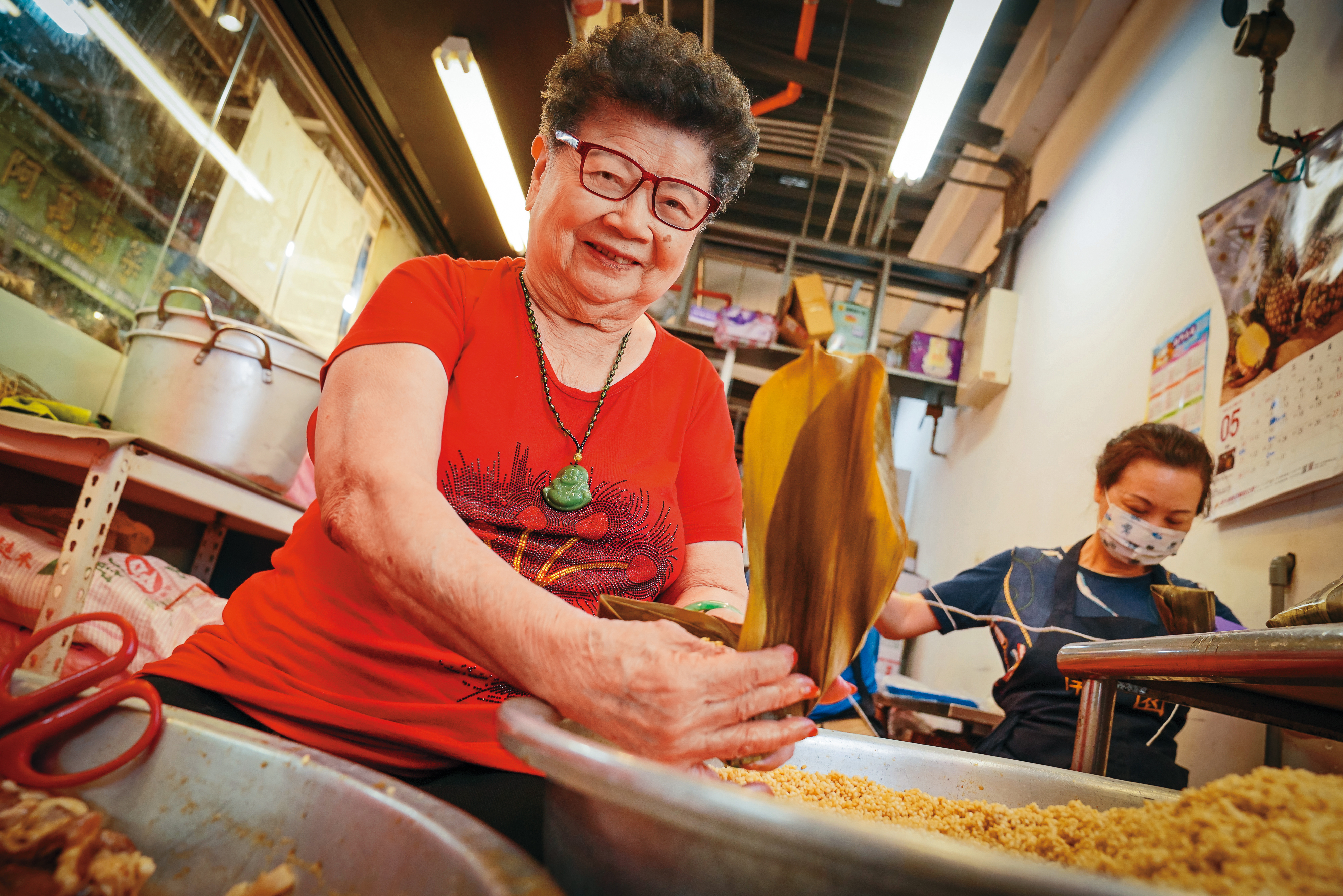 南園食品創始人鍾曾春玉（左），高齡90歲，仍每天清晨就到南門市場鋪上坐鎮。她固守的家鄉味已陪伴台北人近一甲子。