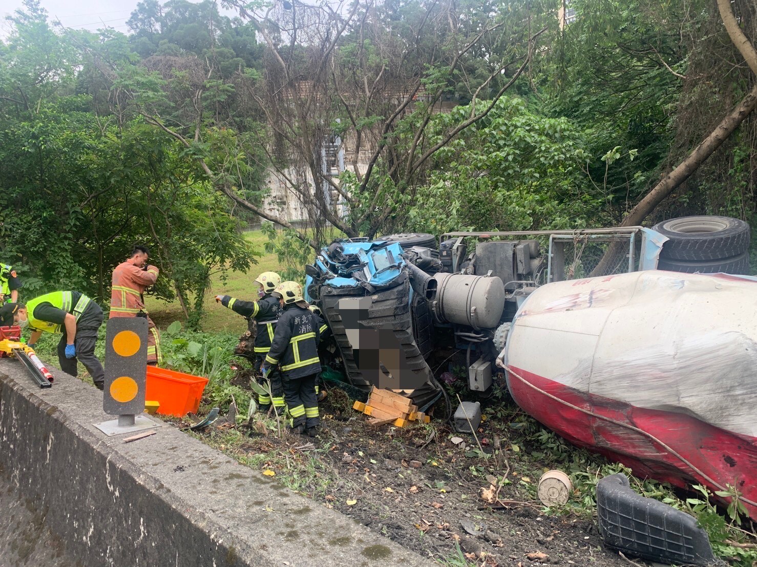 王姓女子今午駕駛水泥預拌車行經國道3號中和段出口時，自撞護欄翻覆邊坡。（翻攝畫面）