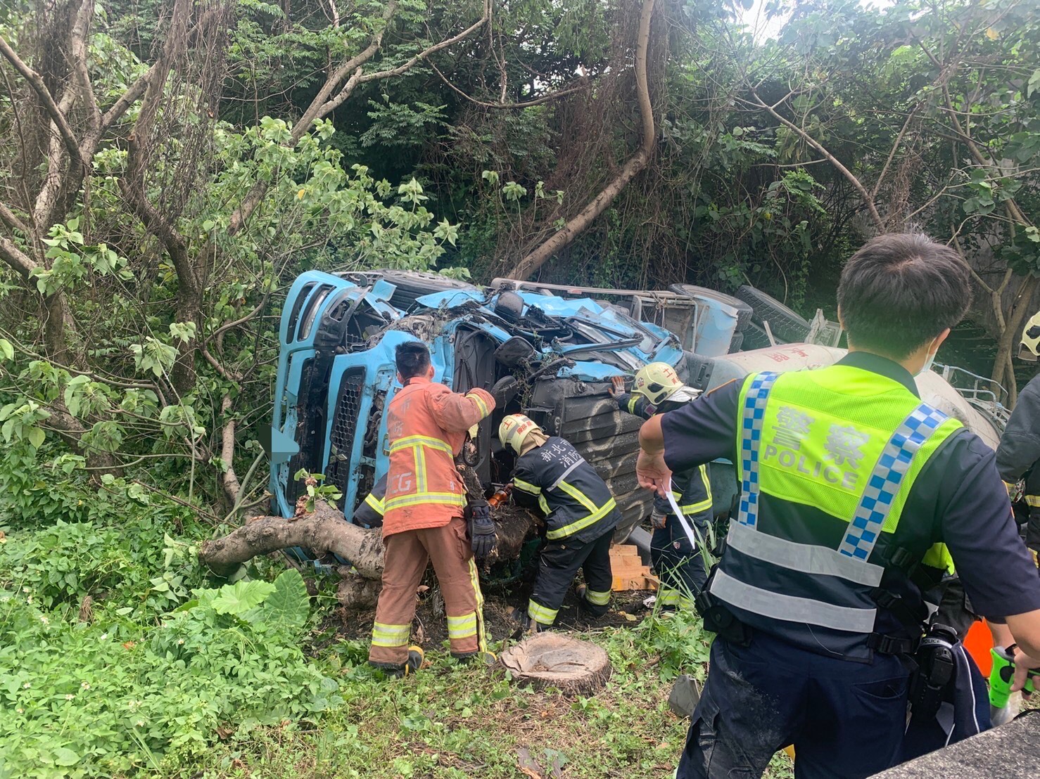 水泥預拌車駕駛受困車內，警消持破壞器材將她救出。（翻攝畫面）