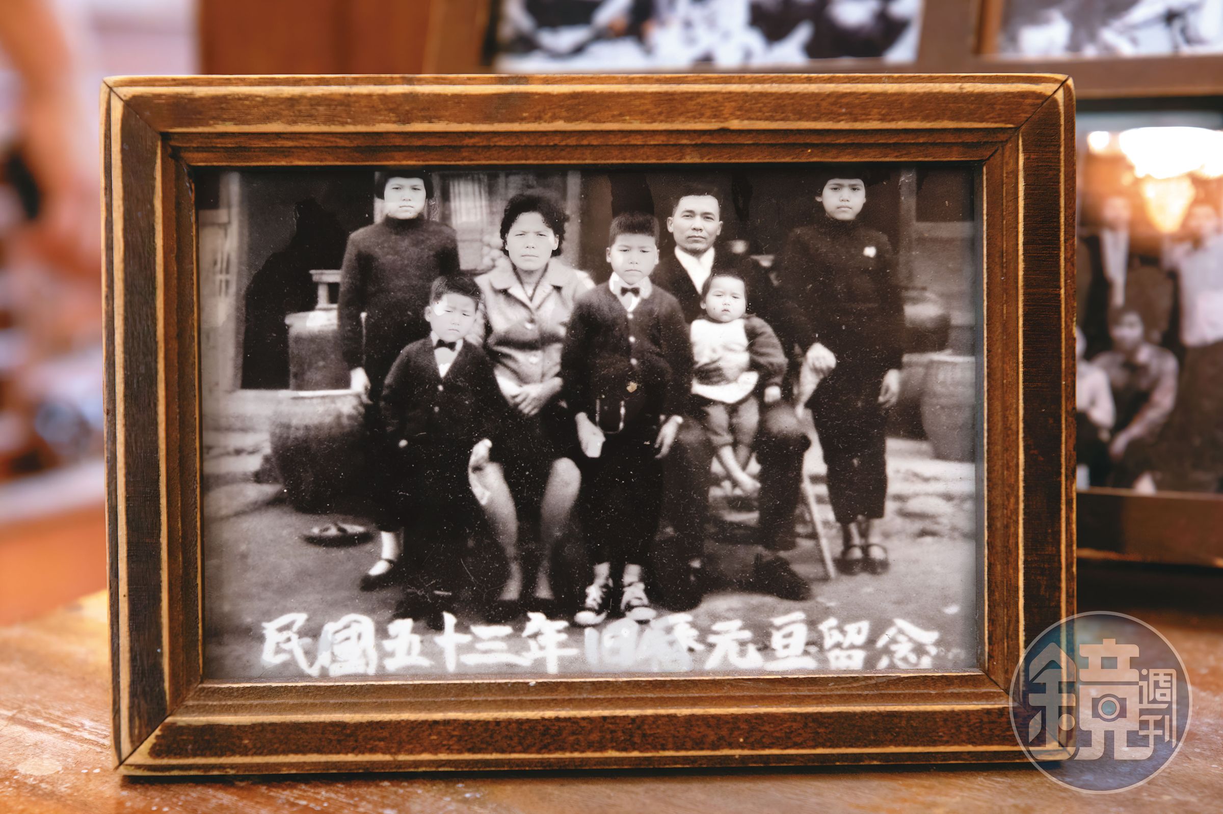 陳天智（中）與母親吳細妹（左3）等家人，在自家五金雜貨店前合照。（陳天智提供）
