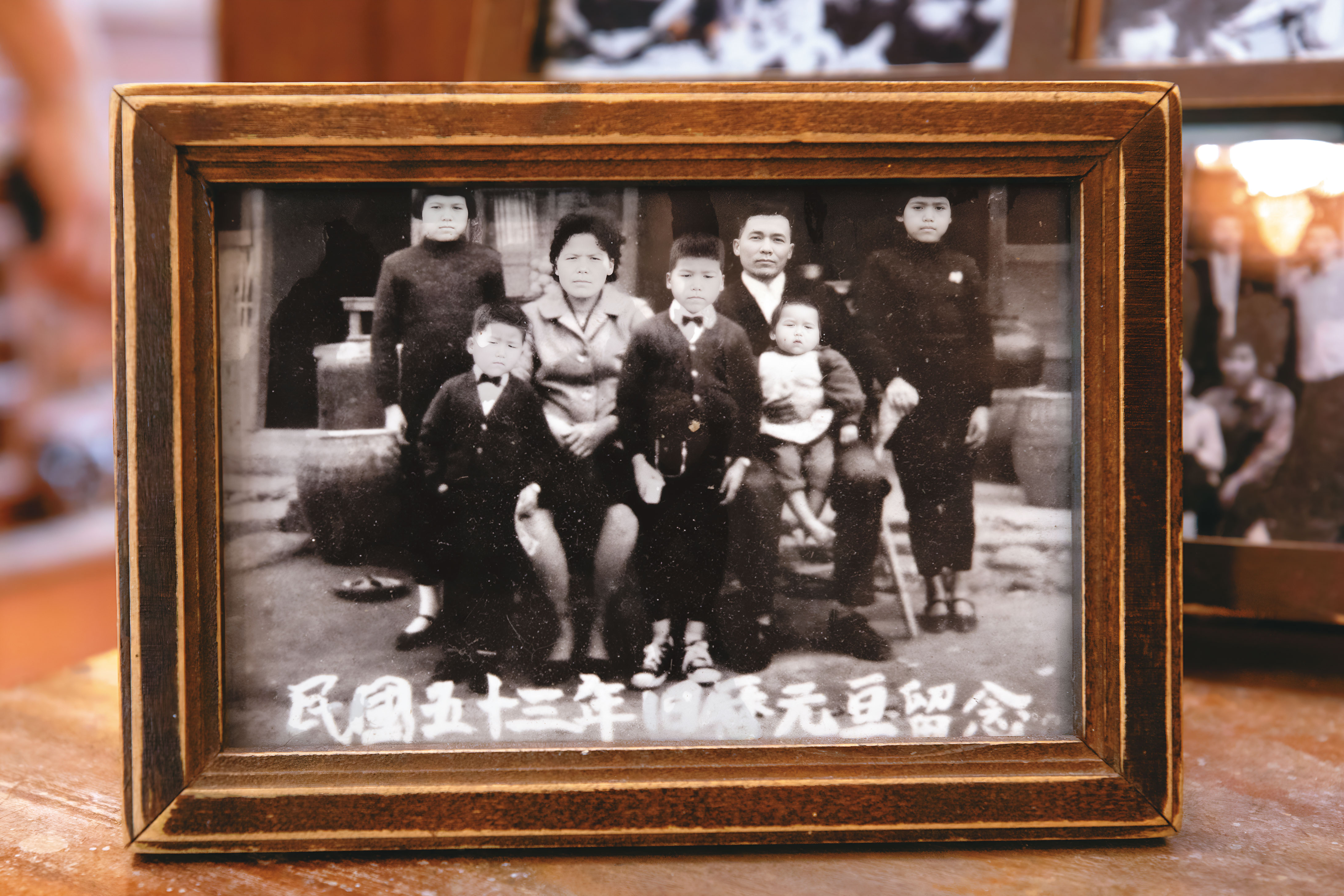 陳天智（中）與母親吳細妹（左3）等家人，在自家五金雜貨店前合照。（陳天智提供）