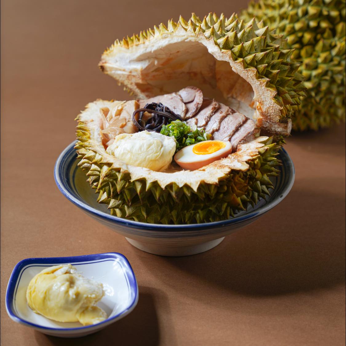 「榴槤拉麵」以椰奶豚骨作為拉麵湯底，再把新鮮的榴槤果肉打成泥融入湯底。（翻攝自山禾堂拉麵岡山店臉書）