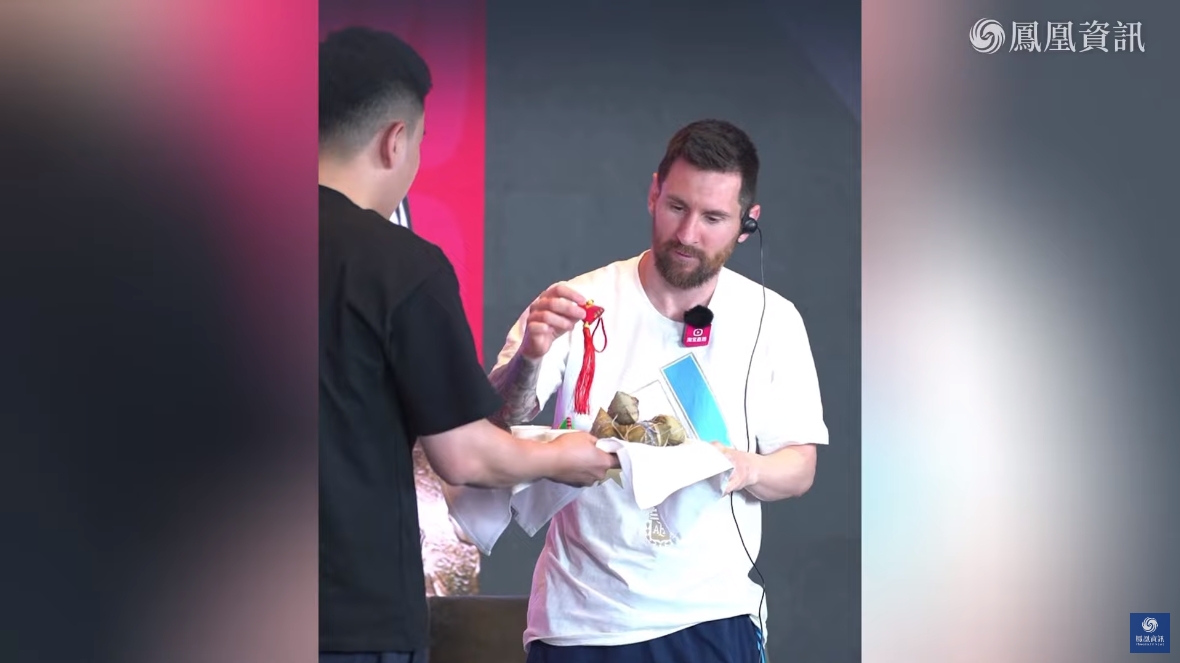 阿根廷球王梅西現身大陸淘寶直播，主持人拿出粽子和香包，並教他說「端午安康」。（翻攝鳳凰資訊YouTube）