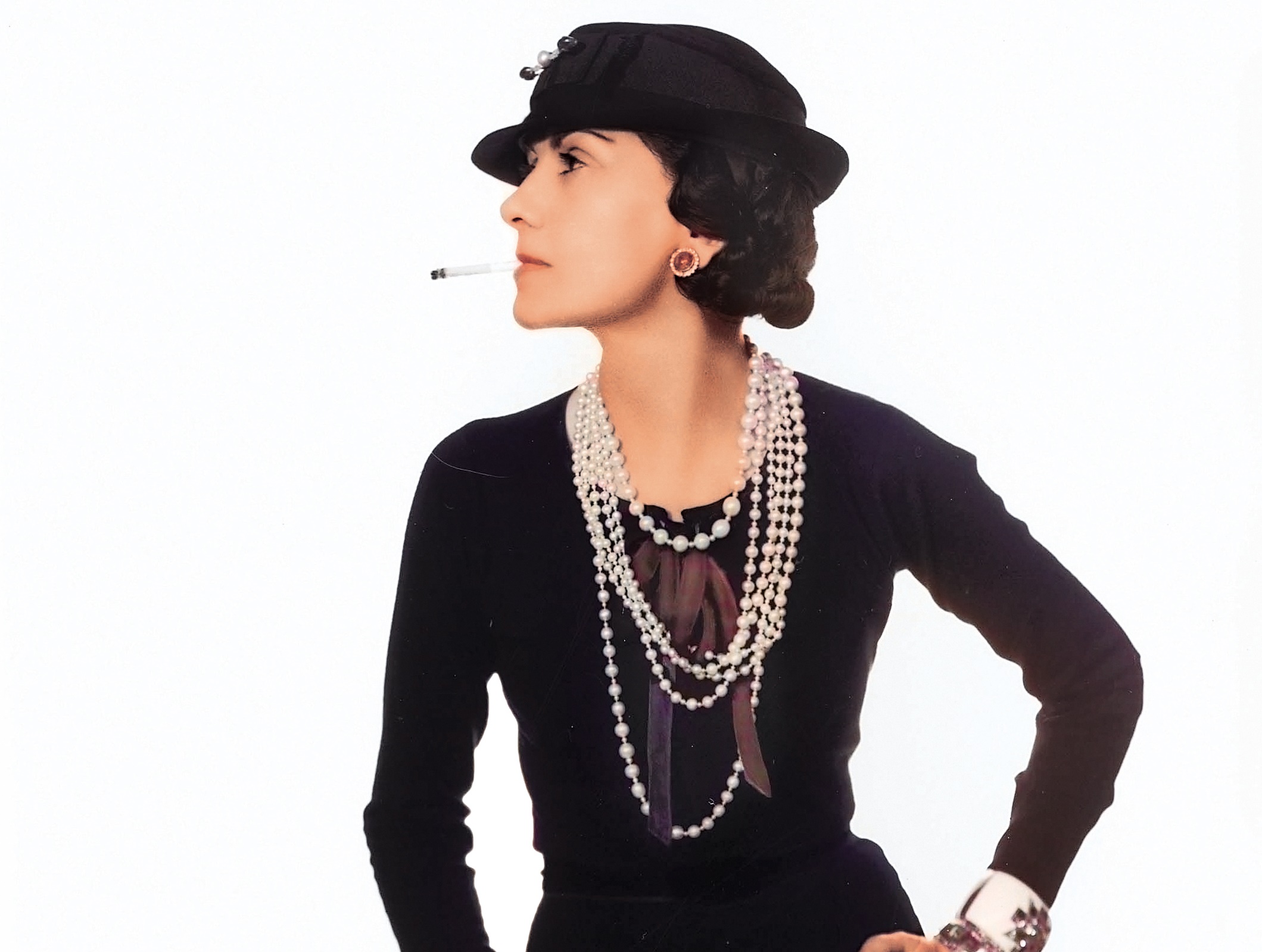 可可香奈兒身穿經典小黑裙搭配珍珠瀑布，是二十世紀最偉大時尚設計師。