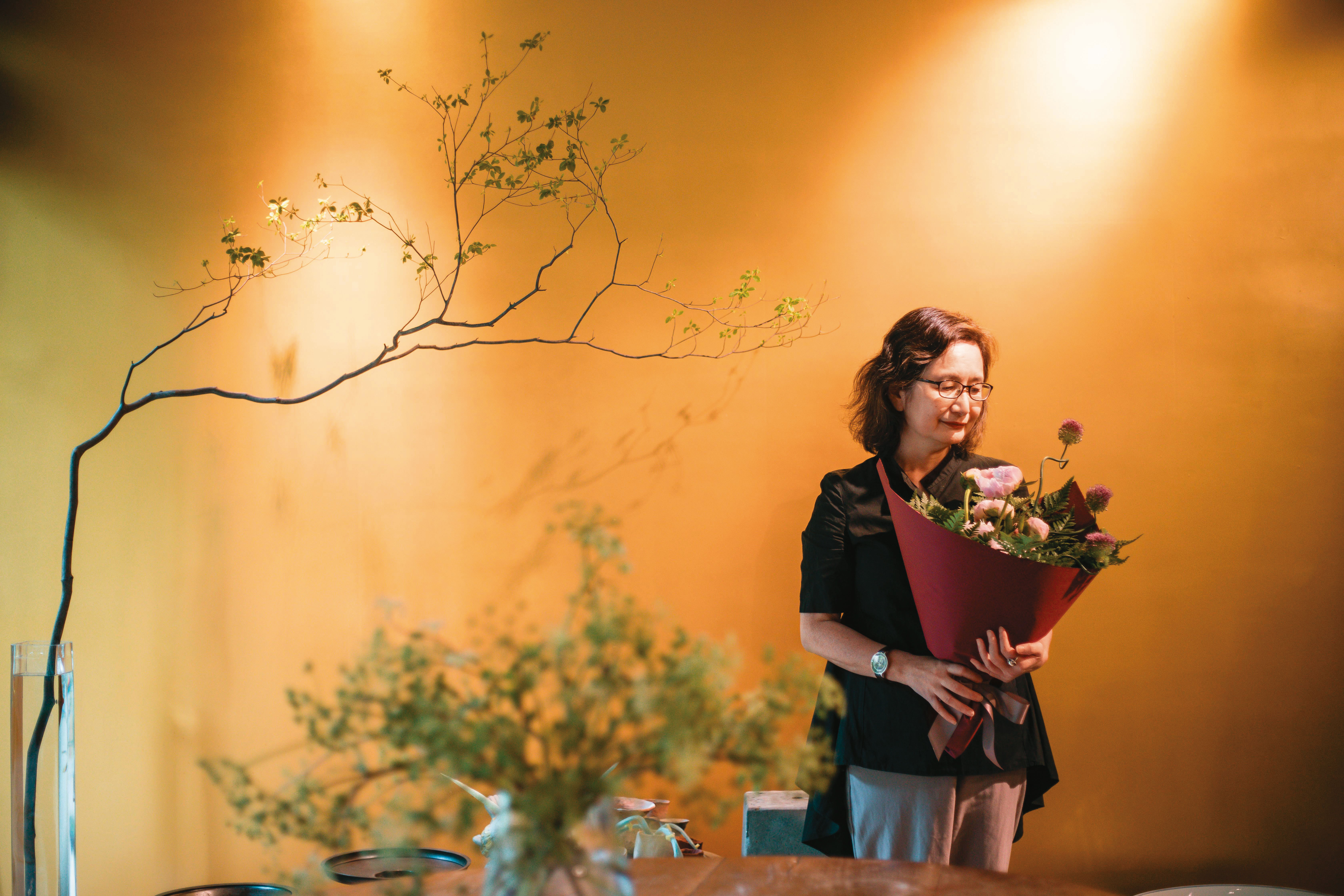 李靜宜習畫、插花多年，定期前往教室練習。我們立夏過後來到她的花藝教室，這天她手邊有曇花、玫瑰，速速就固定、包裝好花材。