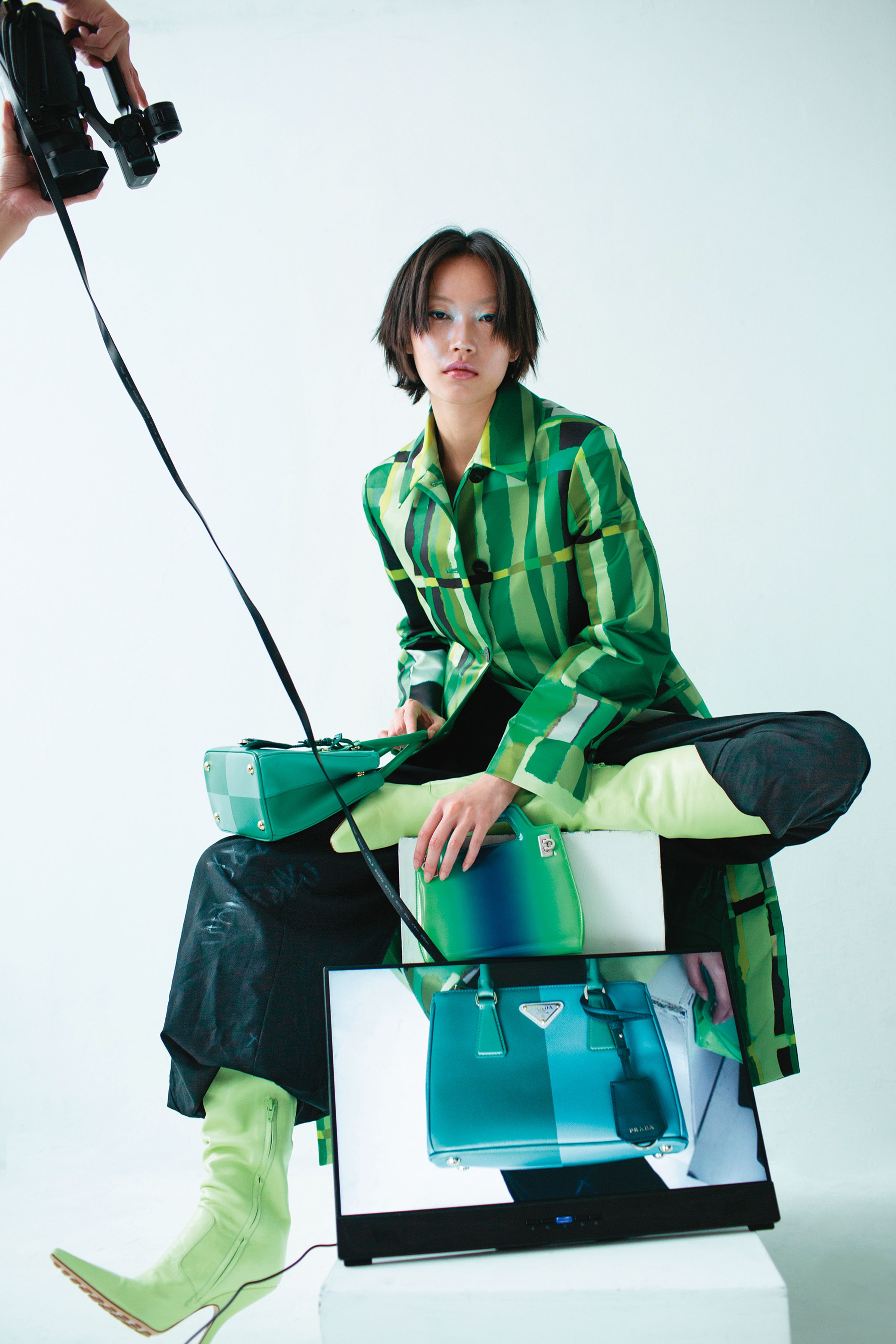 （右上）藍綠漸層迷你Wanda手提包 NT$72,900 by FERRAGAMO／（左、右下）小號Galleria Saffiano皮革特別版手袋 NT$240,000 by PRADA／綠色格紋大衣 NT$87,900 by FERRAGAMO／黑色寬版長褲 價格店洽 by BALENCIAGA／淡綠色尖頭皮靴 價格店洽 by BOTTEGA VENETA