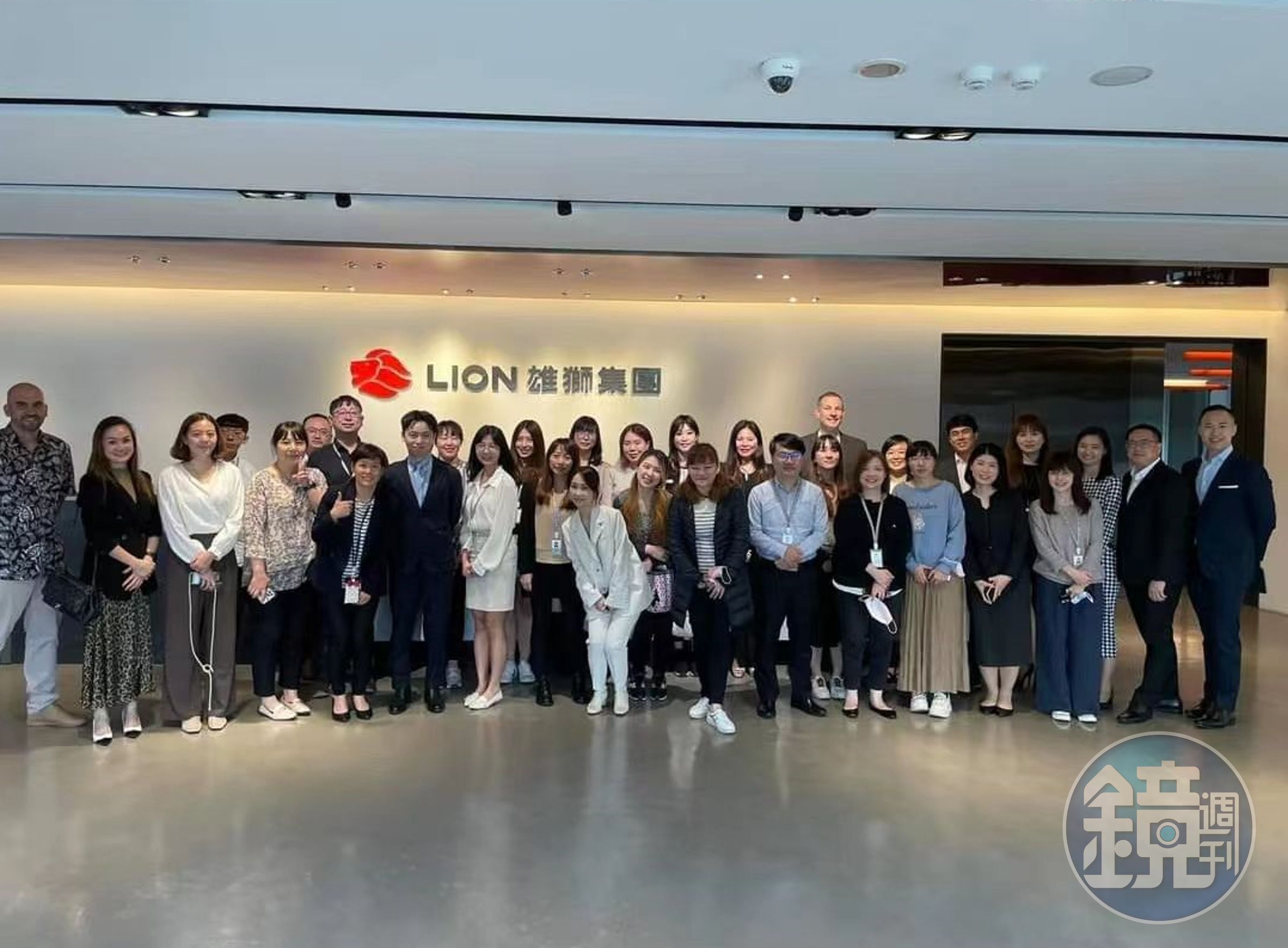 高睿騰（第1排左6、黑西裝淺藍領帶者）與雄獅集團員工合照。（翻攝畫面）