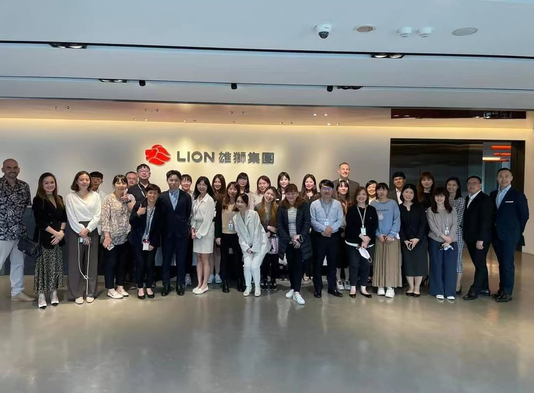 高睿騰（第1排左6、黑西裝淺藍領帶者）與雄獅集團員工合照。（翻攝畫面）