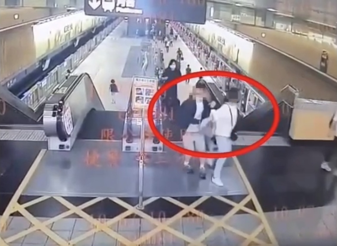 一名女乘客不慎踩到男子的腳，不滿對方出手反推，氣得拿辣椒水噴灑男子，兩人在手扶梯一路拉扯。（翻攝畫面）