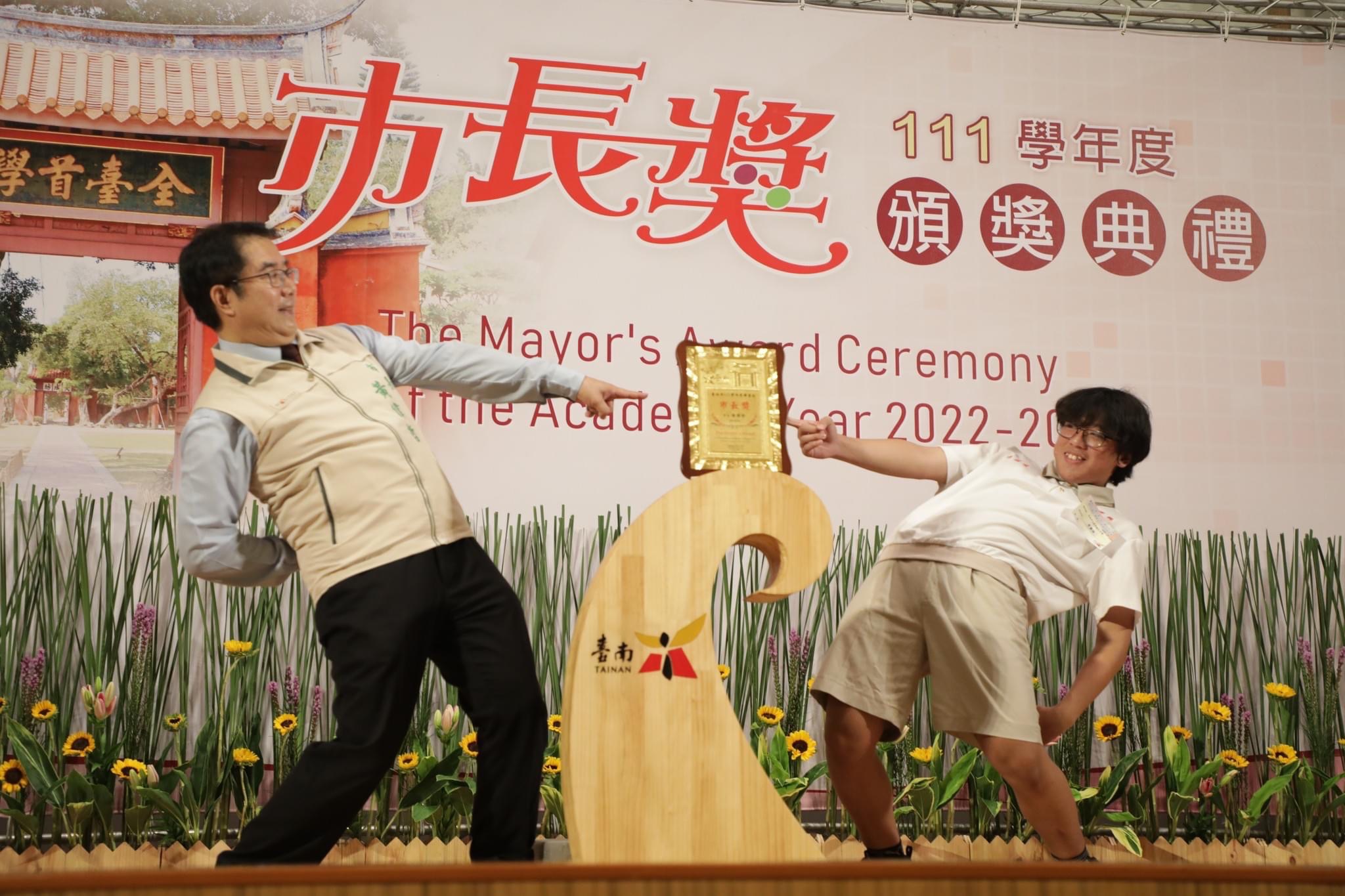 台南市長黃偉哲在市長獎頒獎典禮中，對學生各種創意合照姿勢都盡力配合。（台南市政府提供）