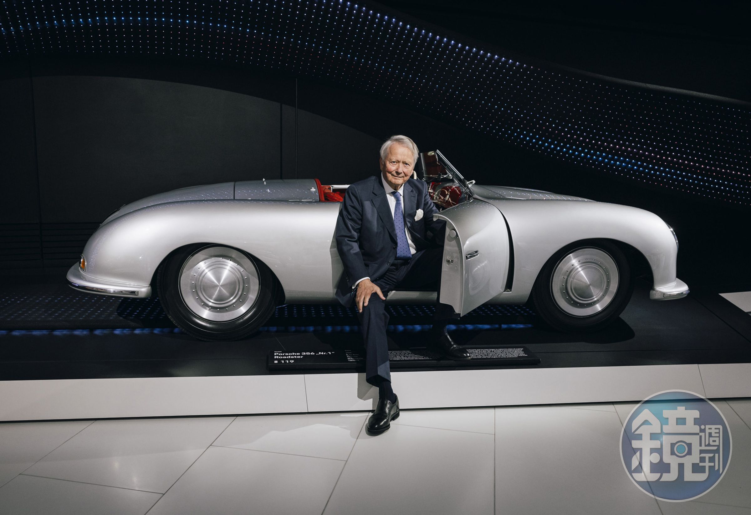 在慶祝PORSCHE 75 周年的晚會上，Porsche家族的一員、也是精神領袖的Dr. Wolfgang Porsche與奠定品牌基石的356「No. 1」Roadster合影。