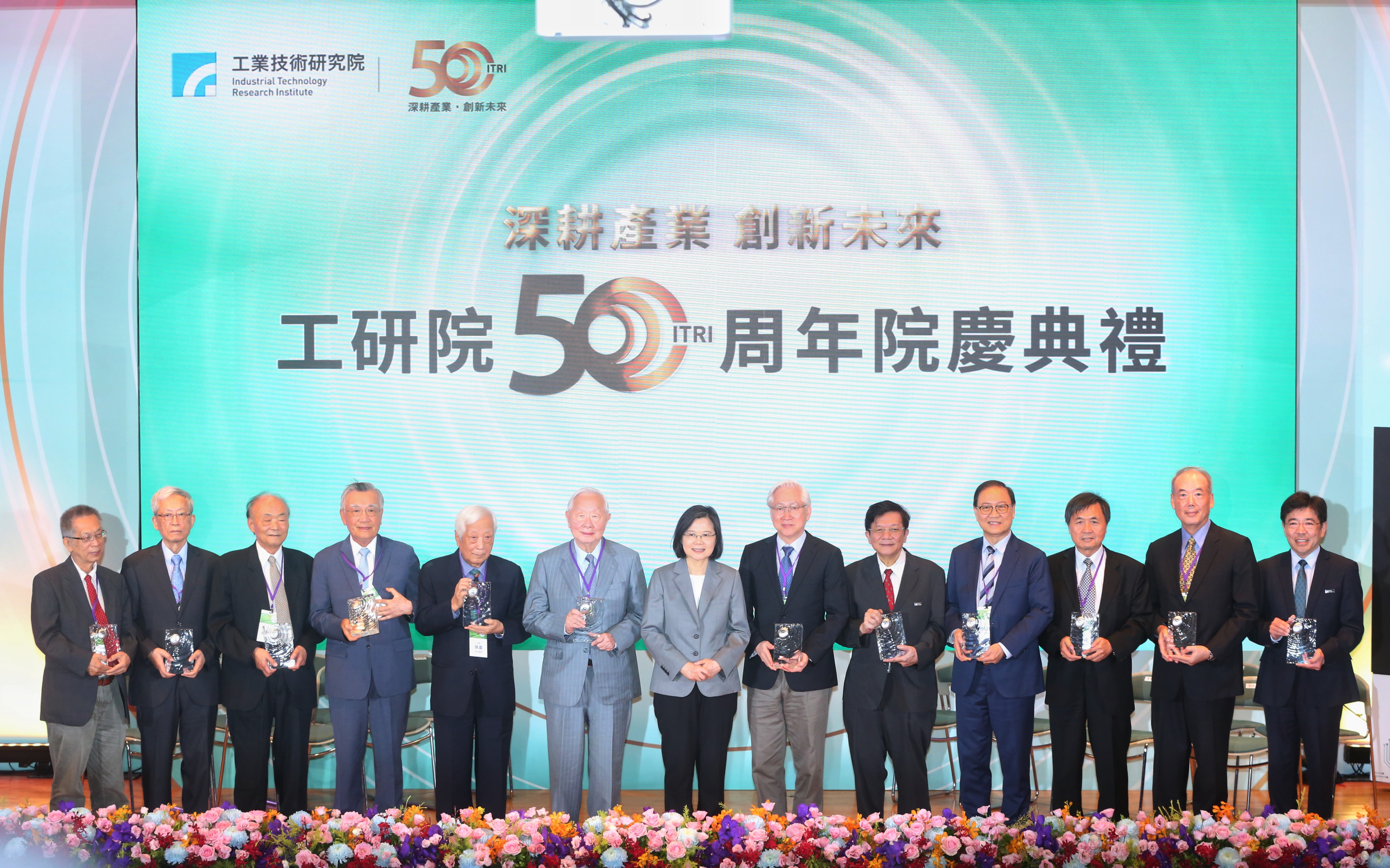 工研院50周年院慶蔡英文總統逐一為12位歷任董事長、院長頒獎，左起為第十任董事長張進福、第九任董事長及第五任院長史欽泰、第七任董事長翁政義、第六與第八任董事長林信義、第五任董事長孫震、第三任董事長及第三任院長張忠謀、總統蔡英文、工研院第十二任董事長吳政忠、第十三任董事長李世光、第六任院長李鍾熙、第七任院長徐爵民、第八任院長劉仲明、現任院長劉文雄。
