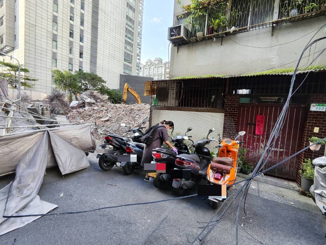 倒塌鷹架波及路邊機車，也把有線電視電纜扯下。（翻攝畫面）