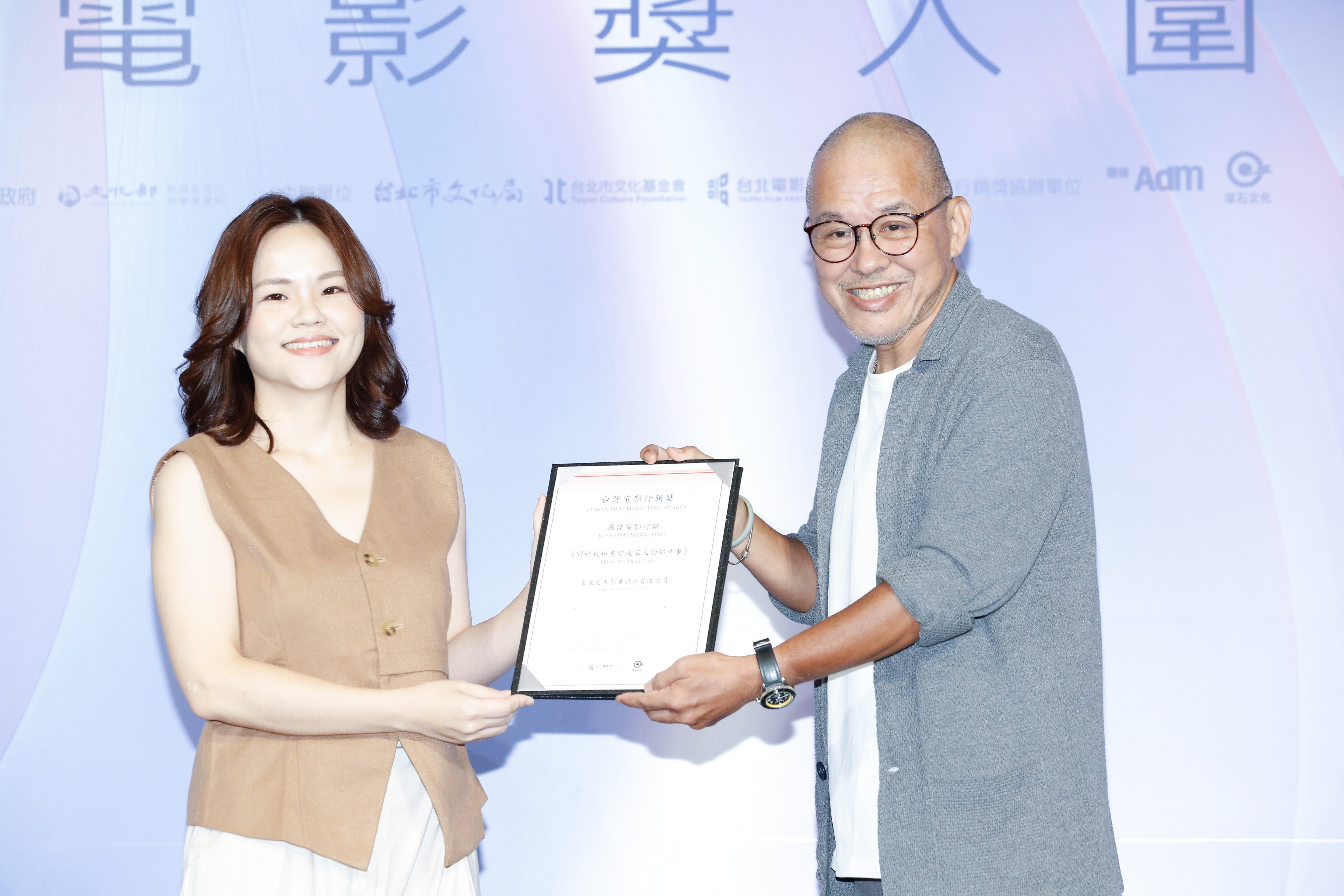 製片陳鴻元（右）頒發「最佳電影行銷」《關於我和鬼變成家人的那件事》給金盞花大影業Emma（左）。
