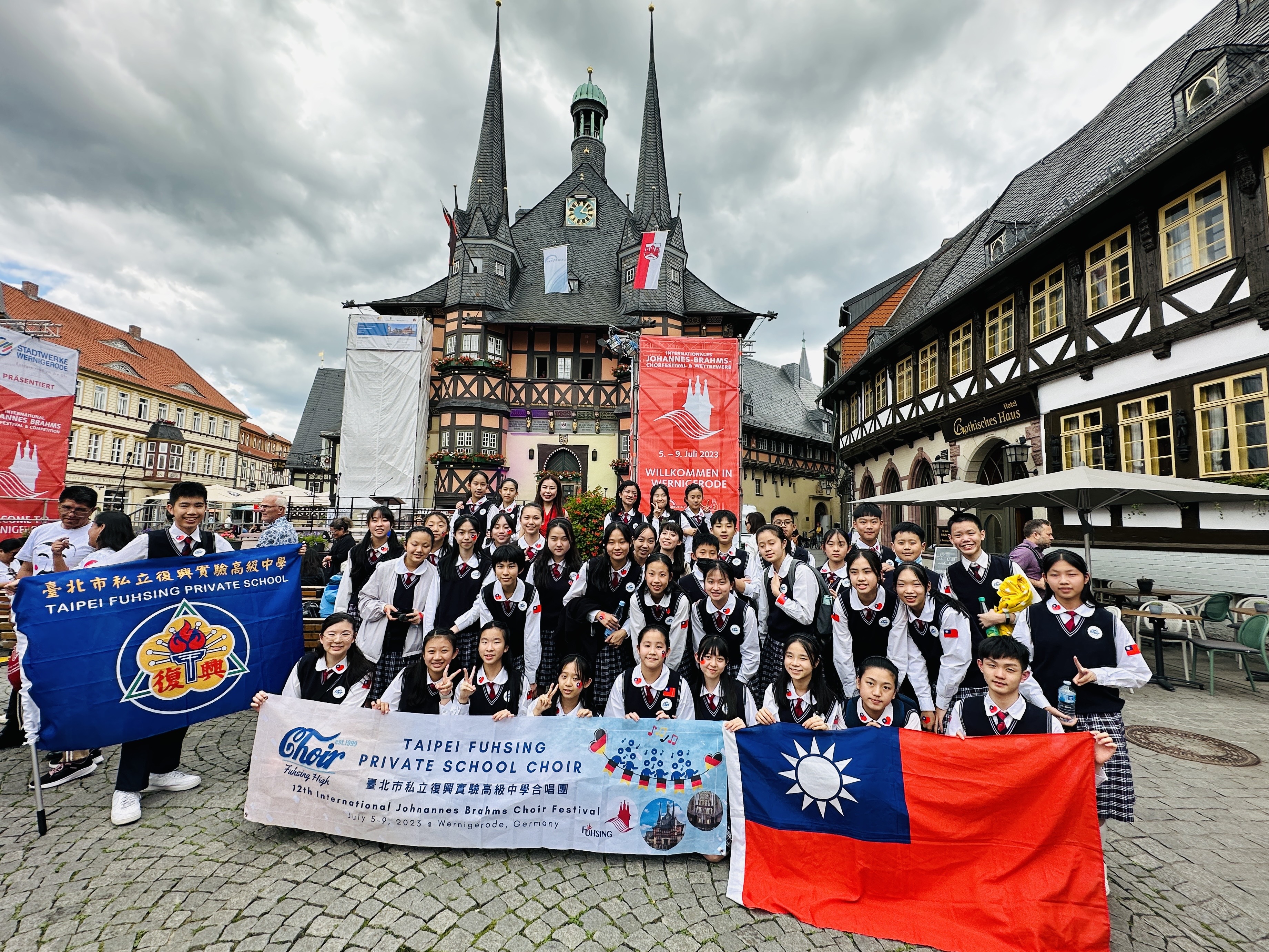 復興中學合唱團赴德國參加國際合唱大賽,獲少兒組金獎以及評審特別獎,團員們拿出國旗合照。(復興中學合唱團提供)