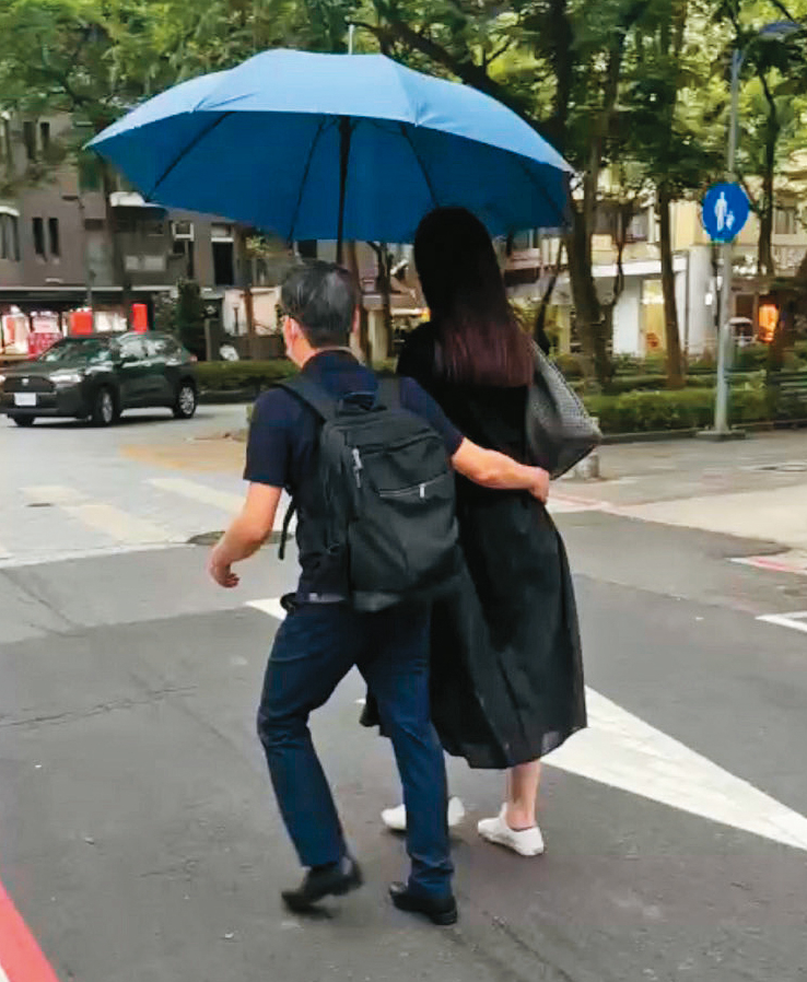 4月19日14:32,張晉源(左)和A女(右)一起撐傘遮陽時,一隻手還不忘摟著女方的腰。