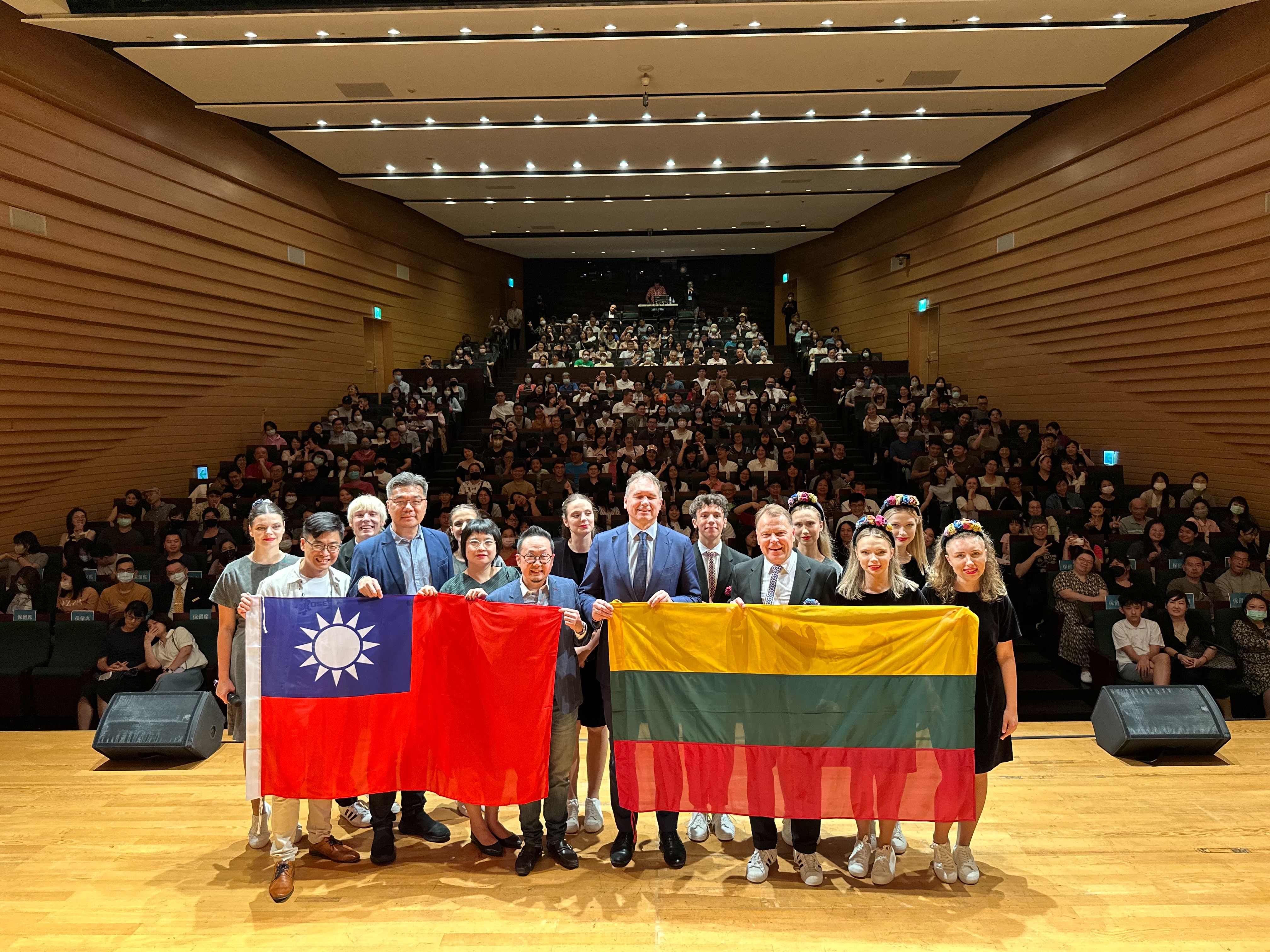 演出後結束後，立陶宛駐台大使盧思融、文化總會秘書長李厚慶更與全場大合照，兩人分別拿著兩國國旗，象徵民主陣線台灣與立陶宛的友好情誼。（文化總會提供）