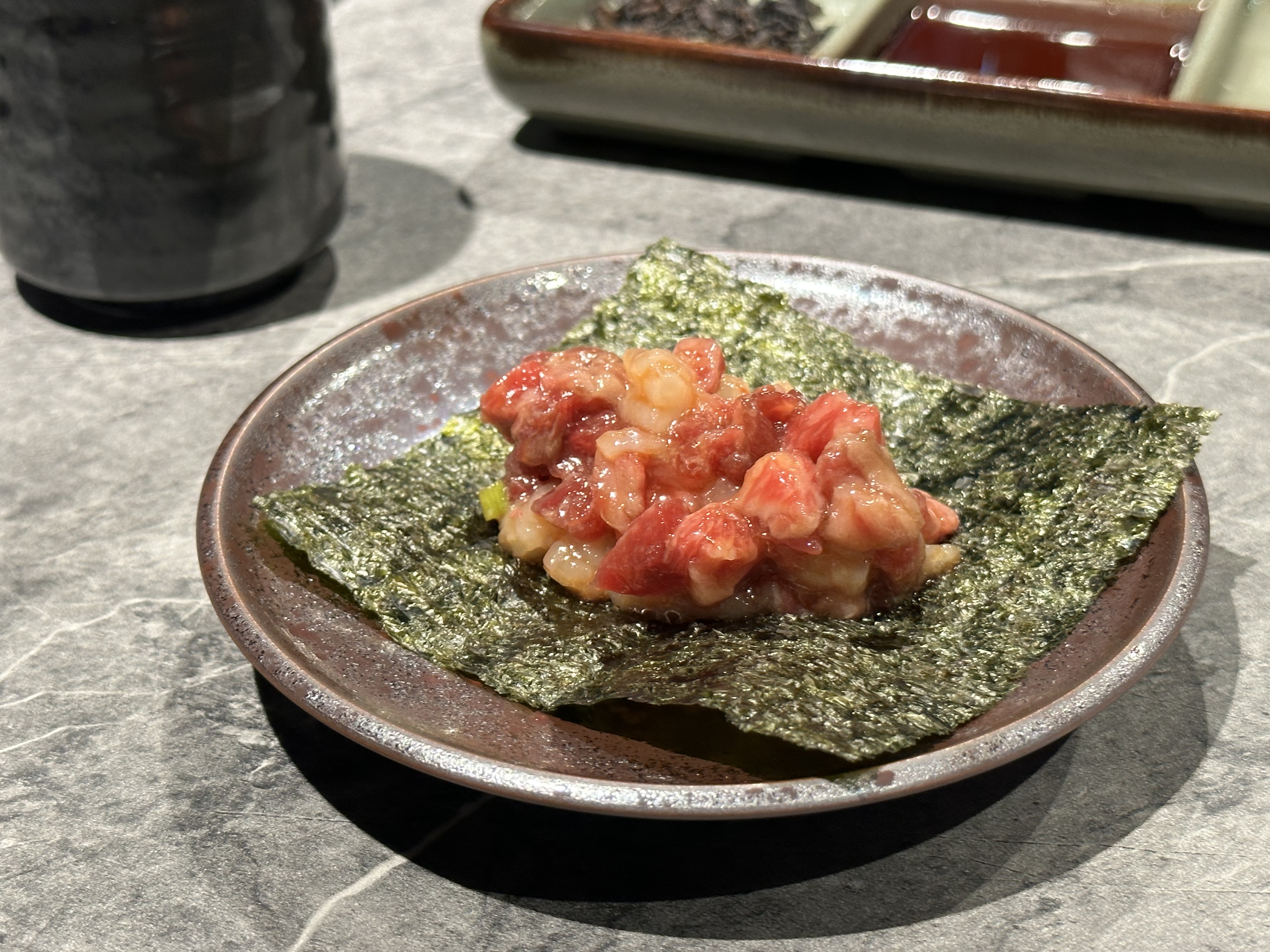 用海苔包著牛肉、甜蝦和紫蘇葉，一口吃很甜美。