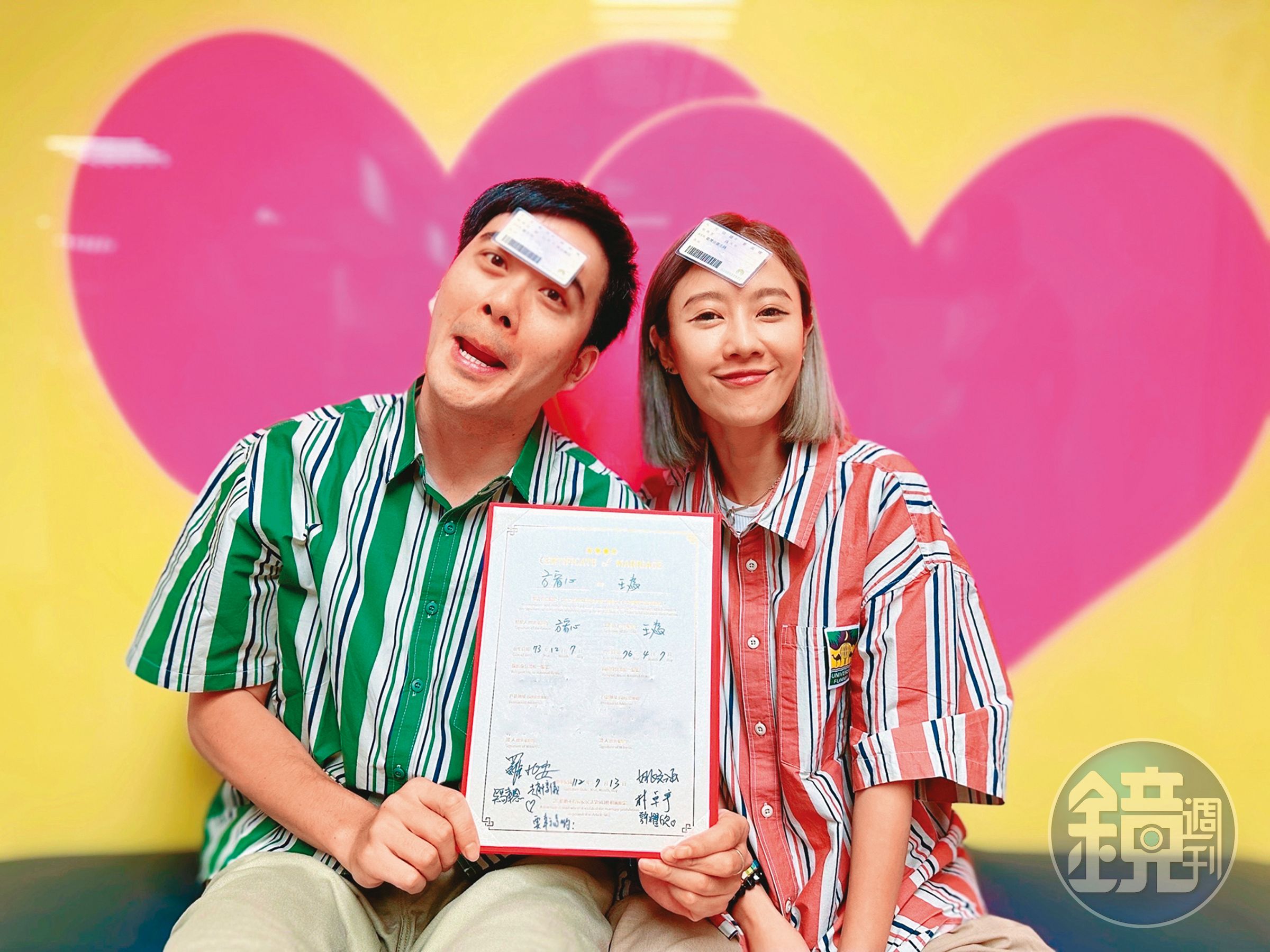 王為(左)和方宥心(右)穿著情侶襯衫,額頭貼著身分證、手拿結婚證書開心合影。(王為提供)