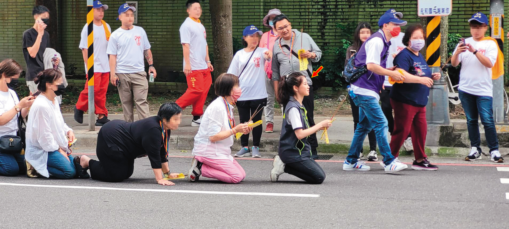 陳紫渝(箭頭處)熱心里上事務,帶著家人及里民在路邊迎媽祖神轎。