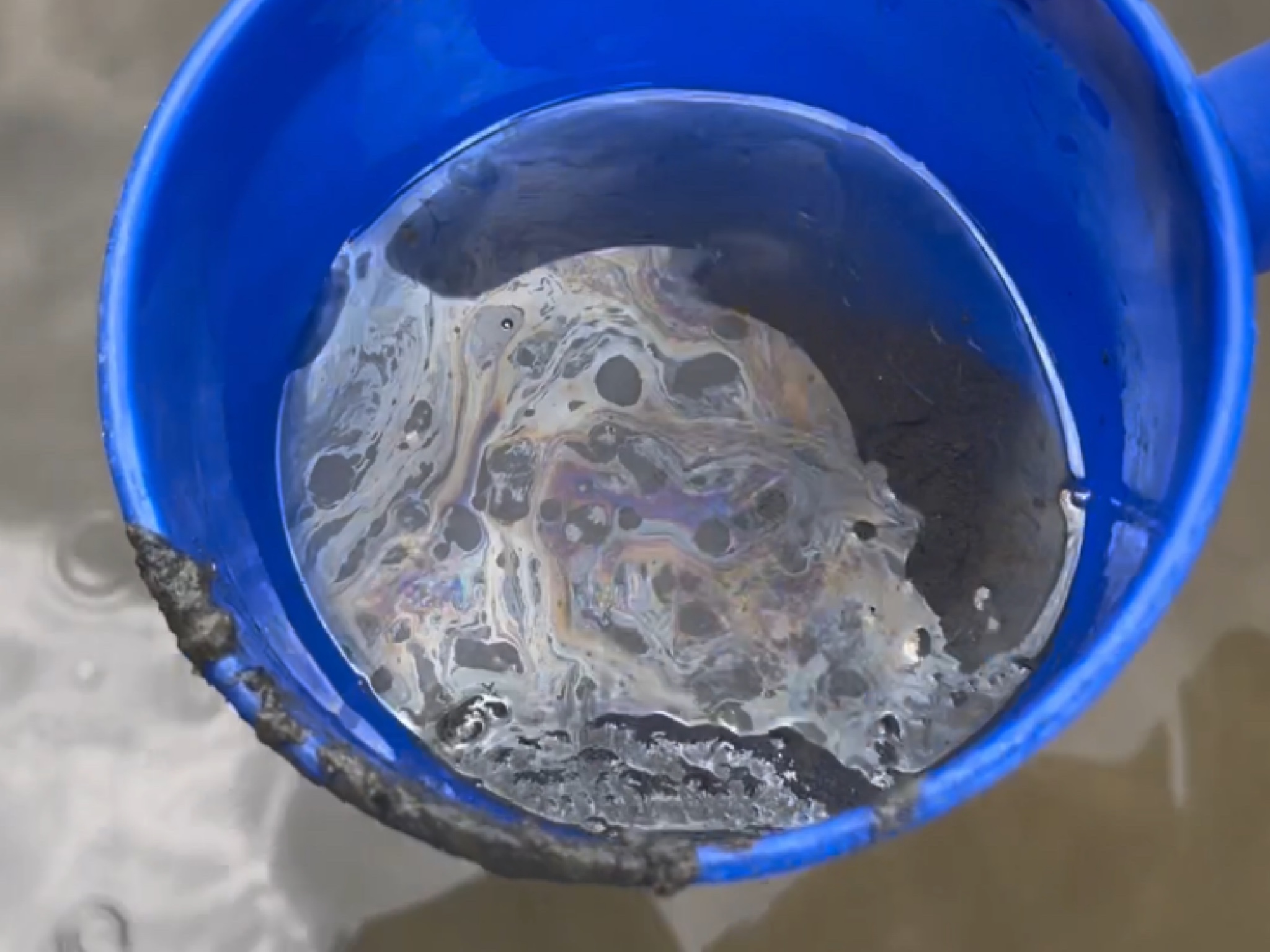 洪申翰等人用鏟子翻攪河床泥土，馬上聞到一股非常濃烈的化學臭味。（洪申翰辦公室提供）
