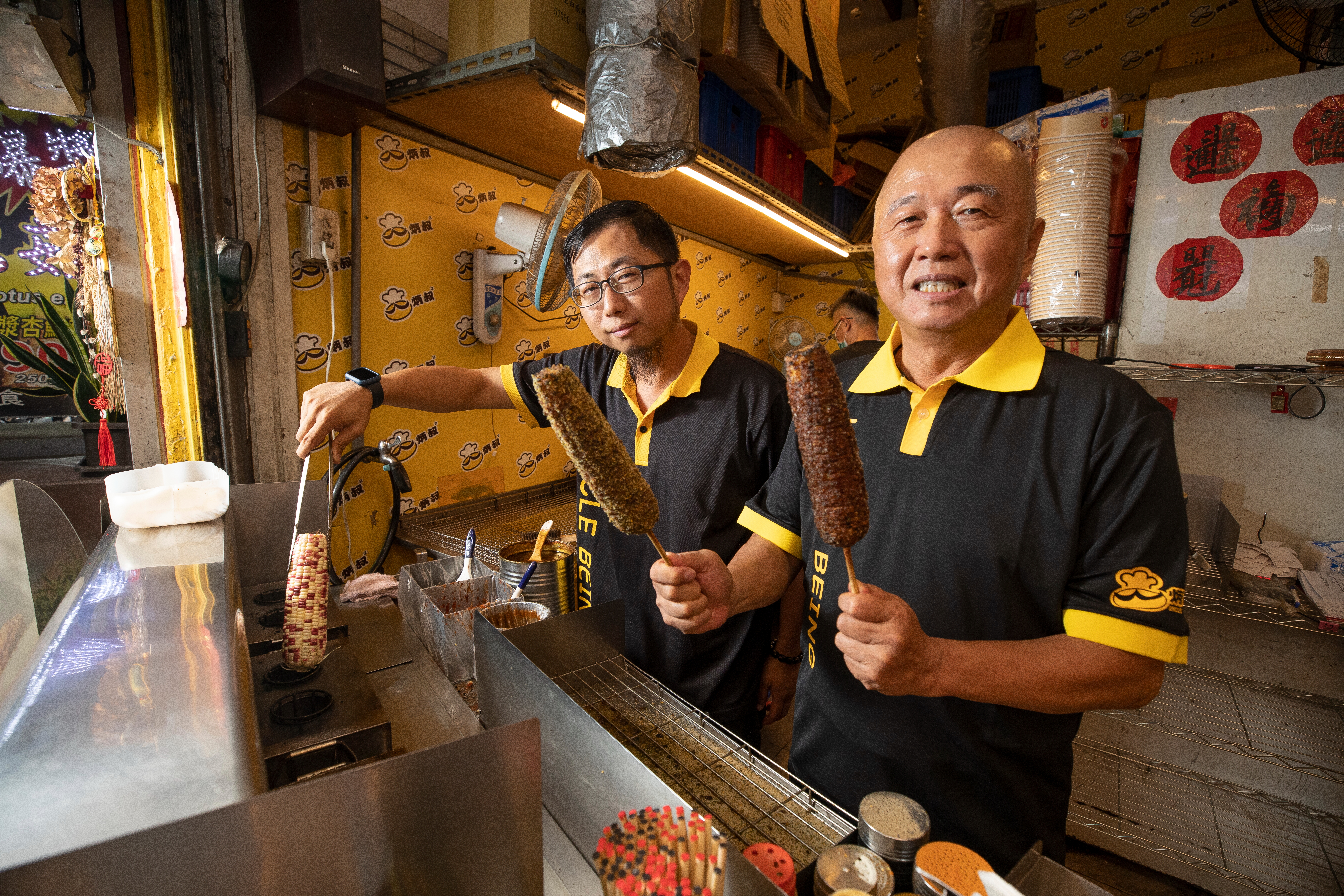 職業軍人出身的胡炳年，退役後曾創業十幾次不成功，後靠烤玉米打出一片天。長子胡智凱（左）則協助他將冷凍烤玉米變成網購夯品。