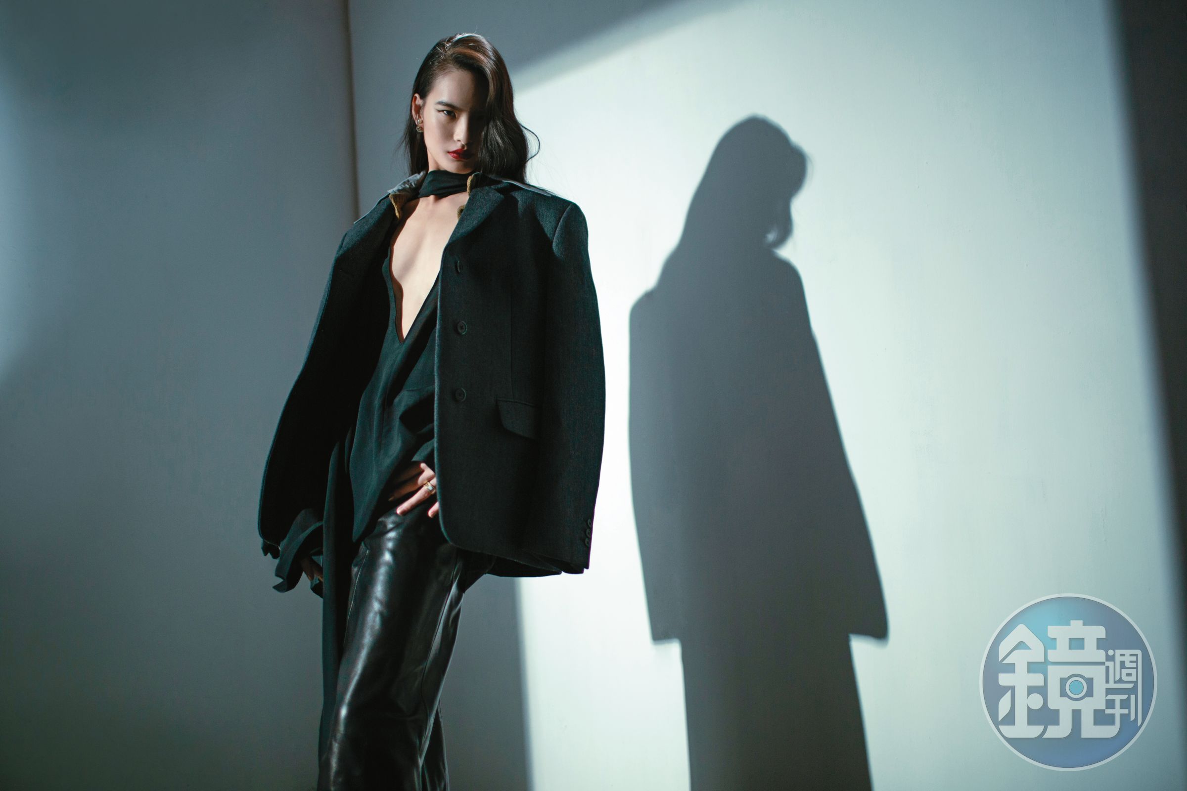 灰色oversize假領片西裝外套 NT$160,000 by PRADA、黑色絲質襯衫 價格店洽、黑色皮革鉛筆裙 價格店洽 by GIVENCHY、珍珠TRIBALES耳環 NT$32,500、金色戒指 NT$19,500 by Dior