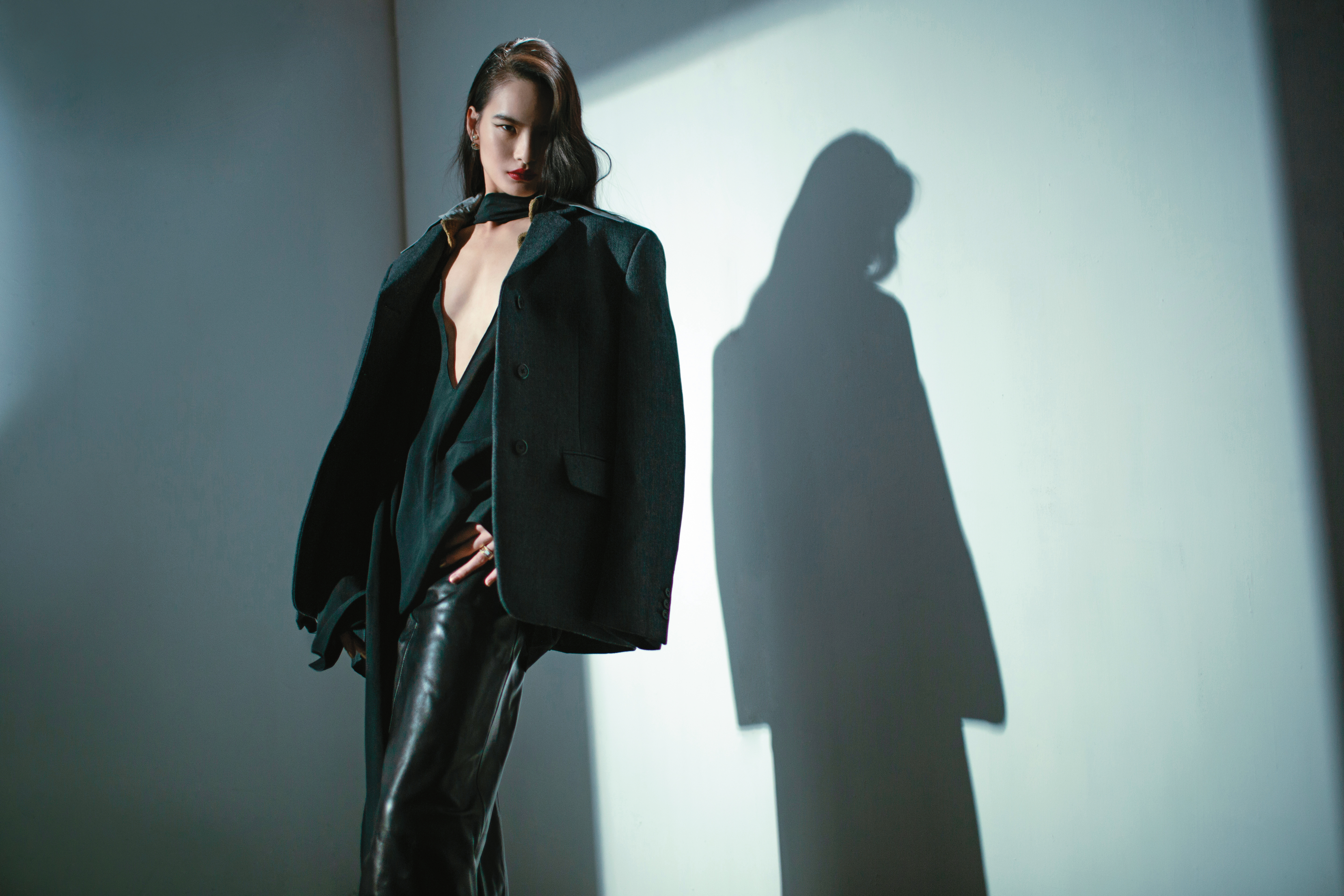 灰色oversize假領片西裝外套 NT$160,000 by PRADA、黑色絲質襯衫 價格店洽、黑色皮革鉛筆裙 價格店洽 by GIVENCHY、珍珠TRIBALES耳環 NT$32,500、金色戒指 NT$19,500 by Dior