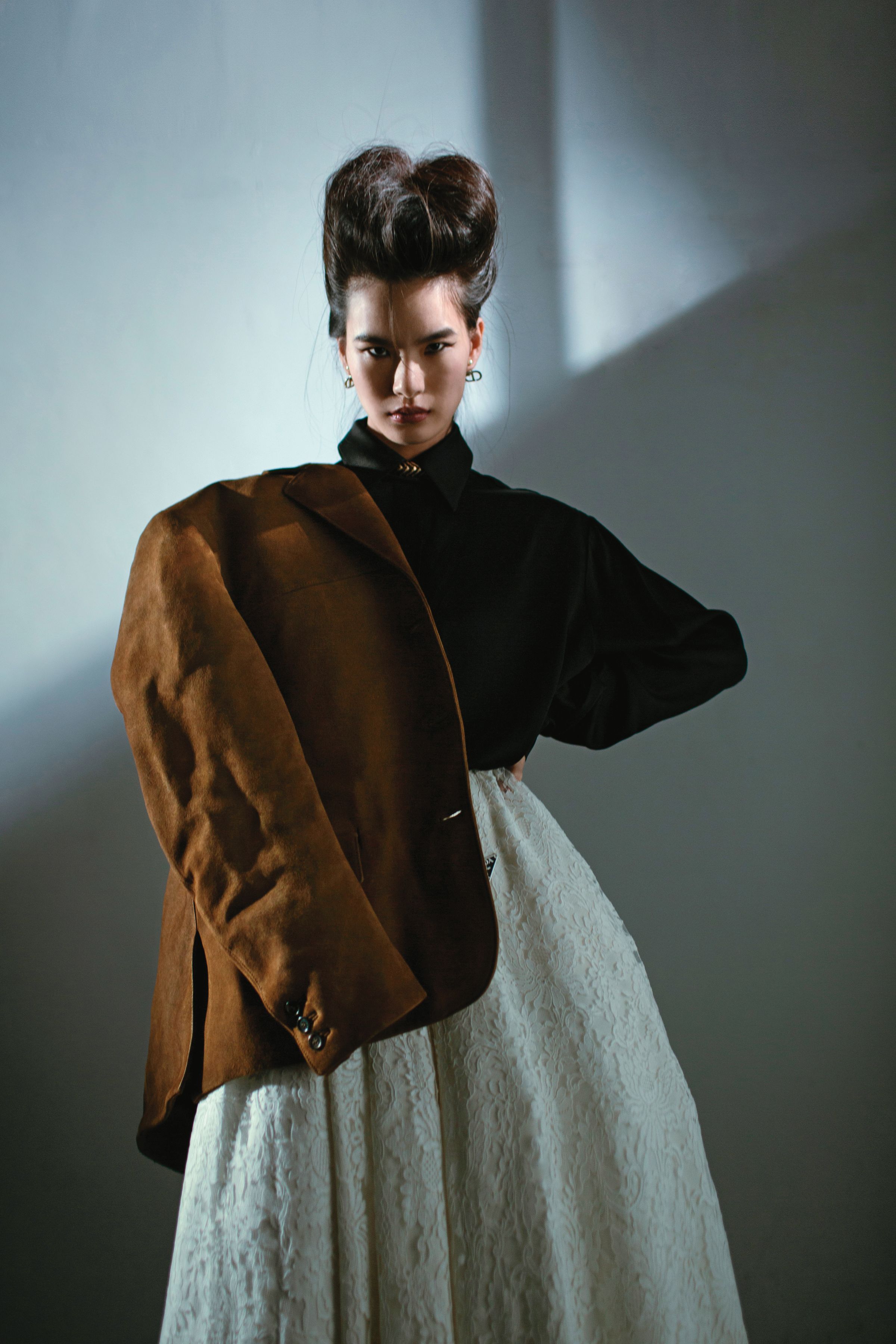 咖啡色麂皮外套 NT$200,000、白色蕾絲蓬裙 NT$330,000  by PRADA、黑色絲緞寬鬆襯衫 NT$31,700 by MICHAEL KORS、珍珠 Logo TRIBALES耳環 NT$20,000 by Dior、金色項鍊 價格店洽 by BOTTEGA VENETA