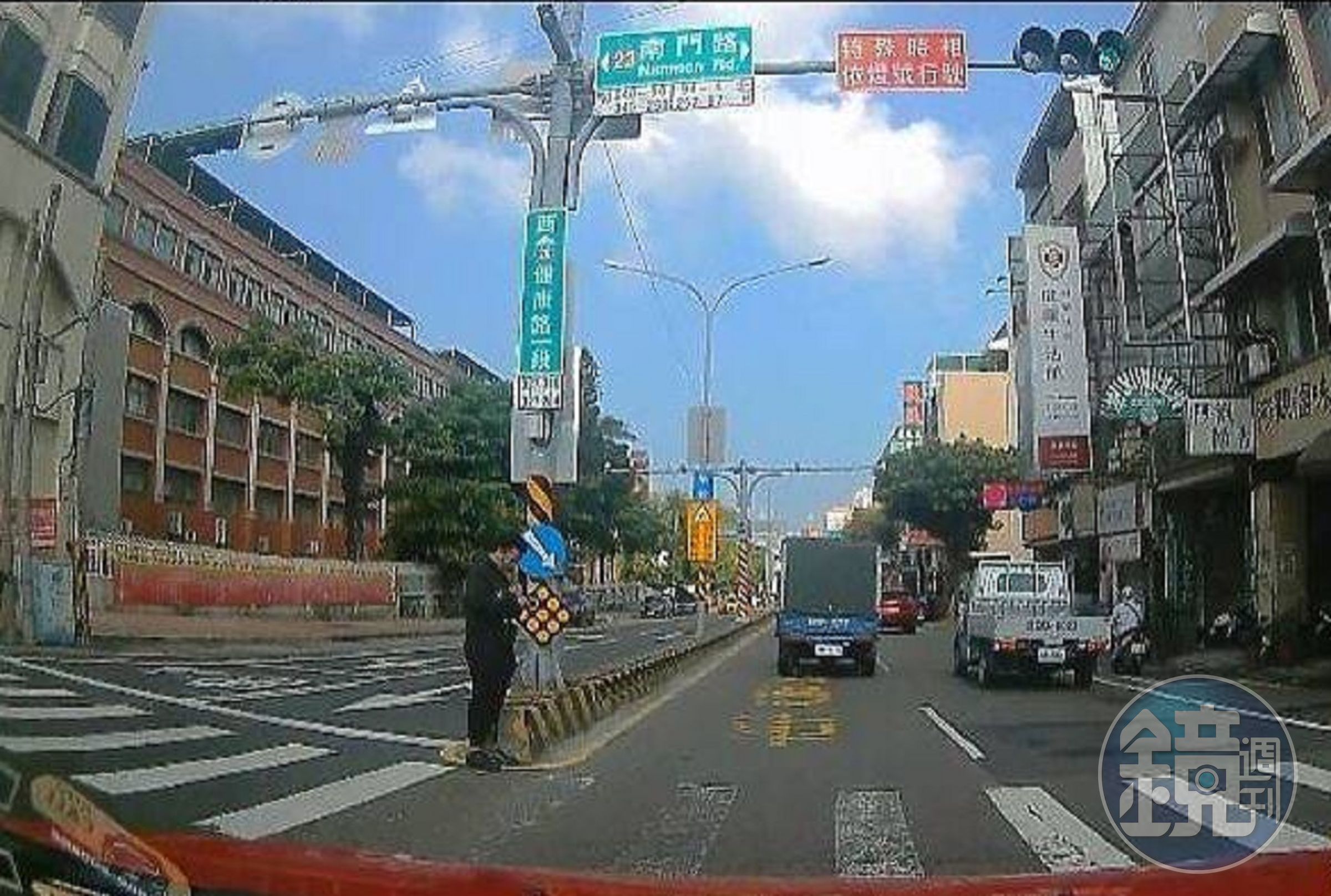 有行人來不及過完整條馬路，停在分隔島處等紅燈，但綠燈通過的車輛遭開6,000元罰單。（翻攝畫面）