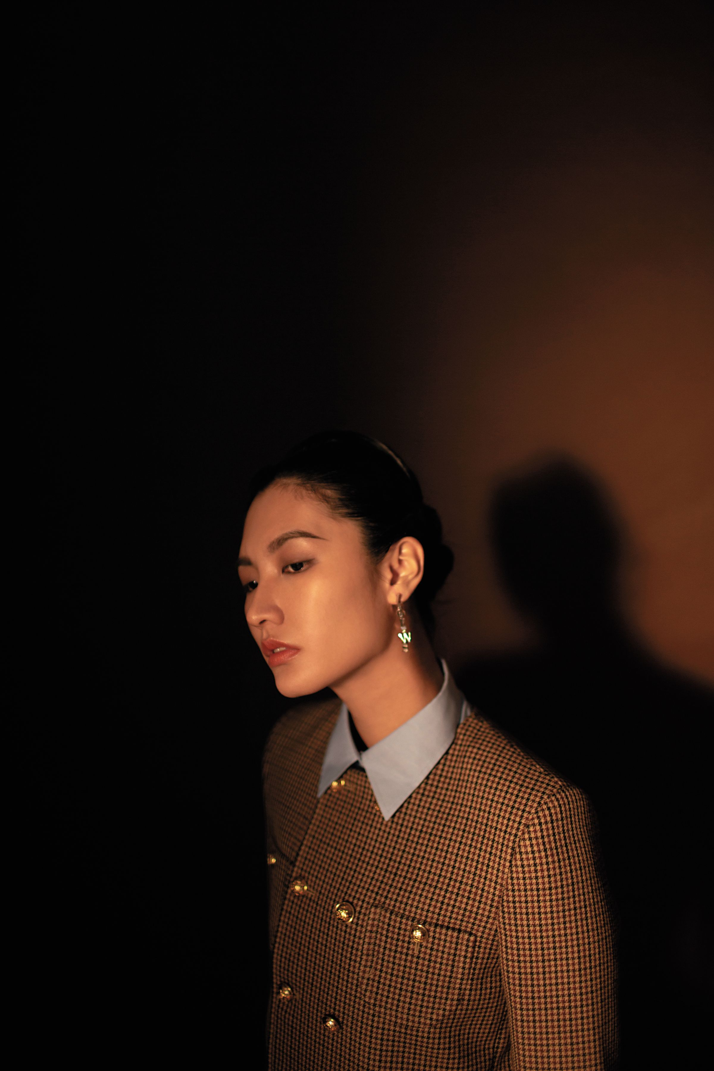 格紋外套 NT$135,000 by CELINE BY HEDI SLIMANE;天藍色長袖棉質襯衫 NT$34,200 by GUCCI;字體耳環 NT$35,000 by LOEWE。