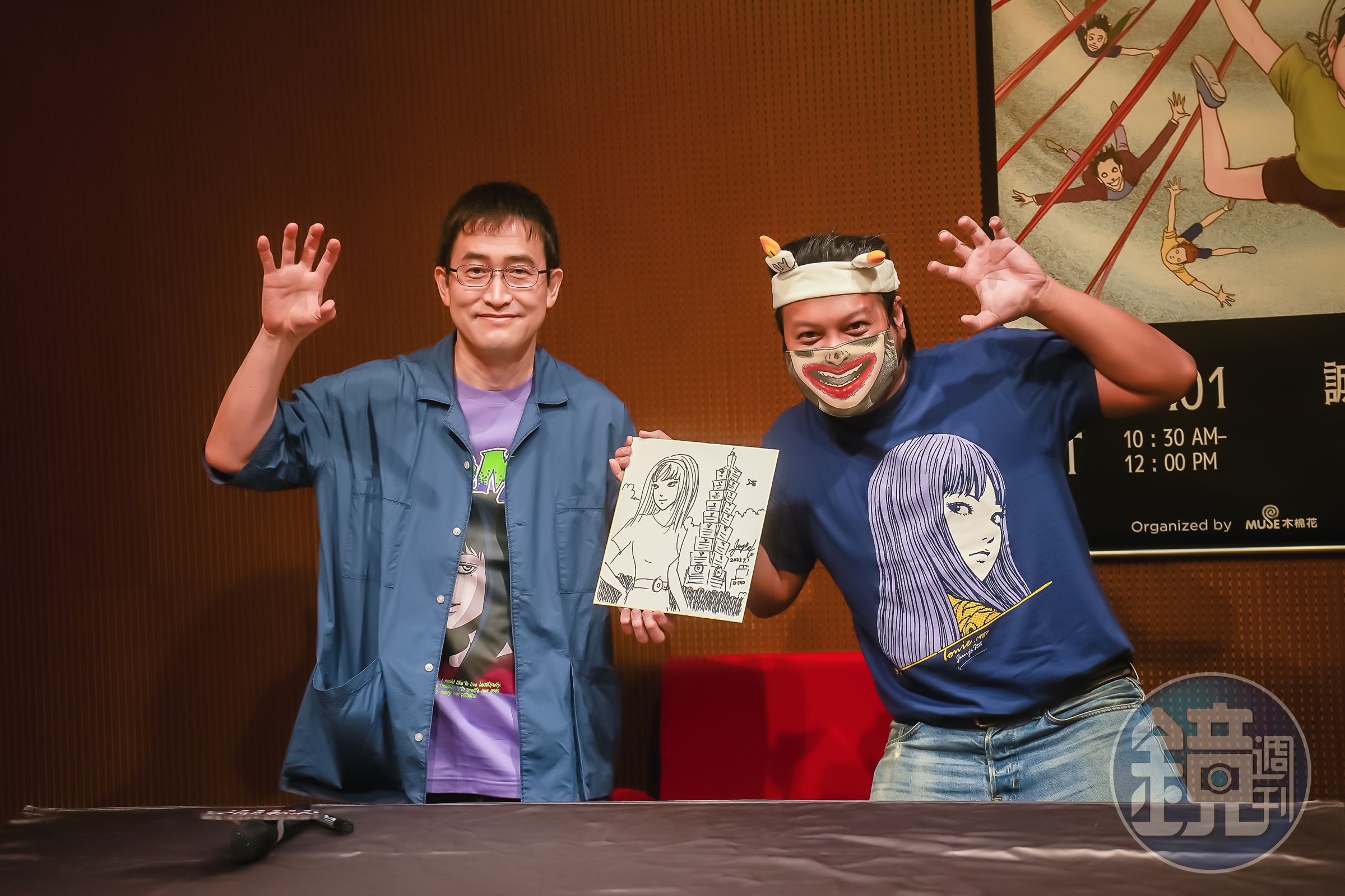 伊藤潤二(左)日前來台出席見面會,現場作畫將台北101結合代表角色富江,送給幸運粉絲。(木棉花國際提供)