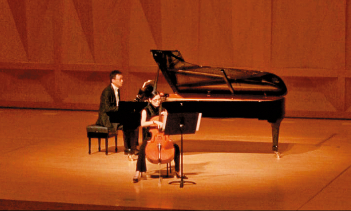 已故導演楊德昌（左）在自己的電影《一一》與鋼琴家妻子彭鎧立（右）同台演出。（翻攝《一一》電影）