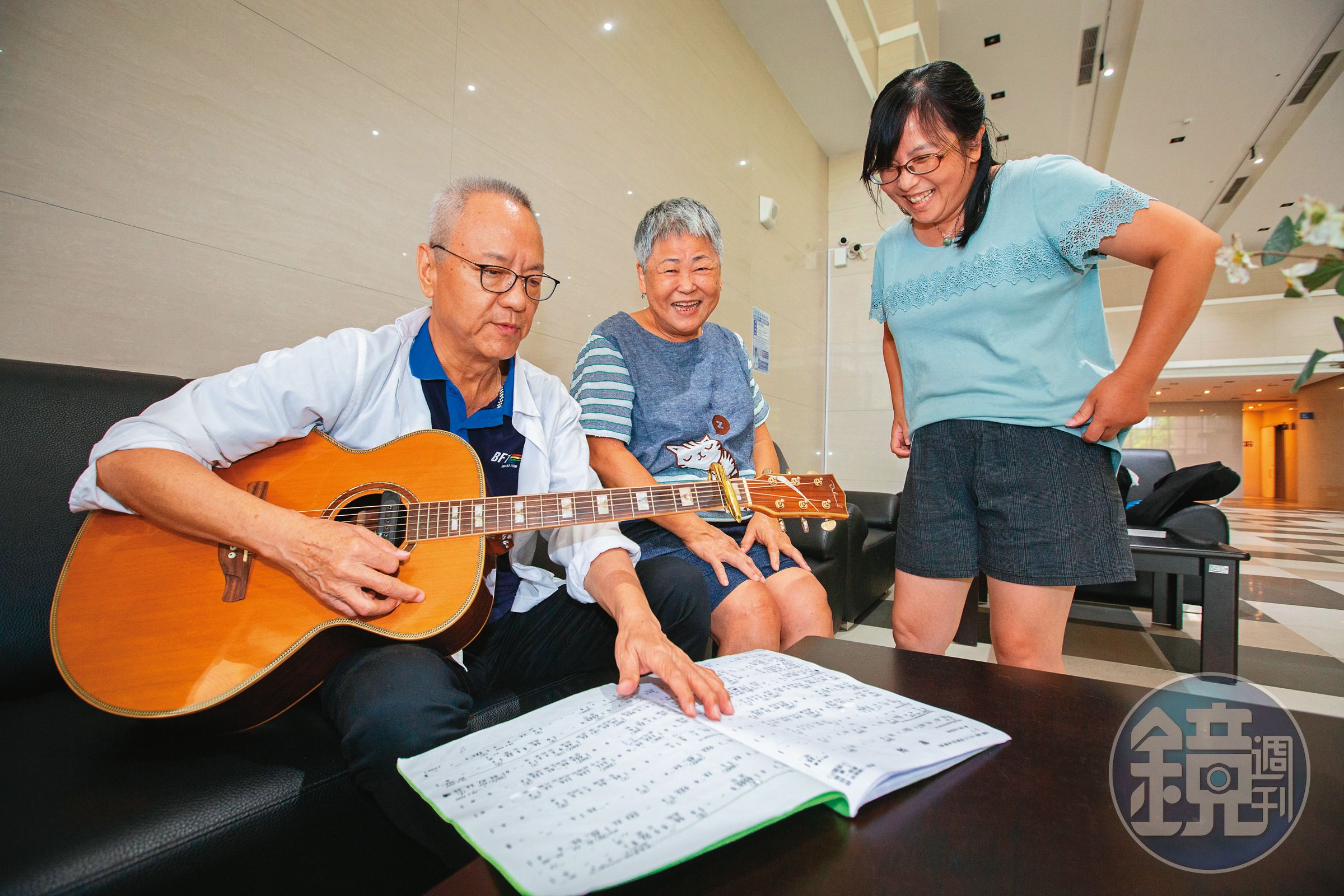 江希陸(左1)退休住進新北市府「青銀共居」社會宅,在大廳自彈自唱,與鄰居同樂。