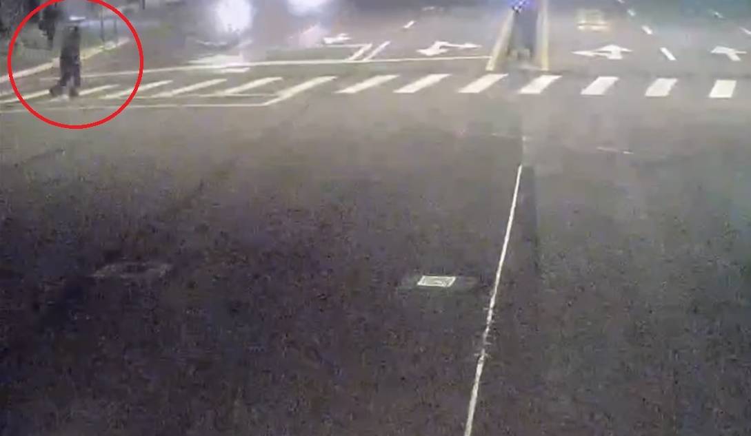 行人（紅圈）清晨闖紅燈穿越馬路，遭2機車前後撞上。（翻攝畫面）