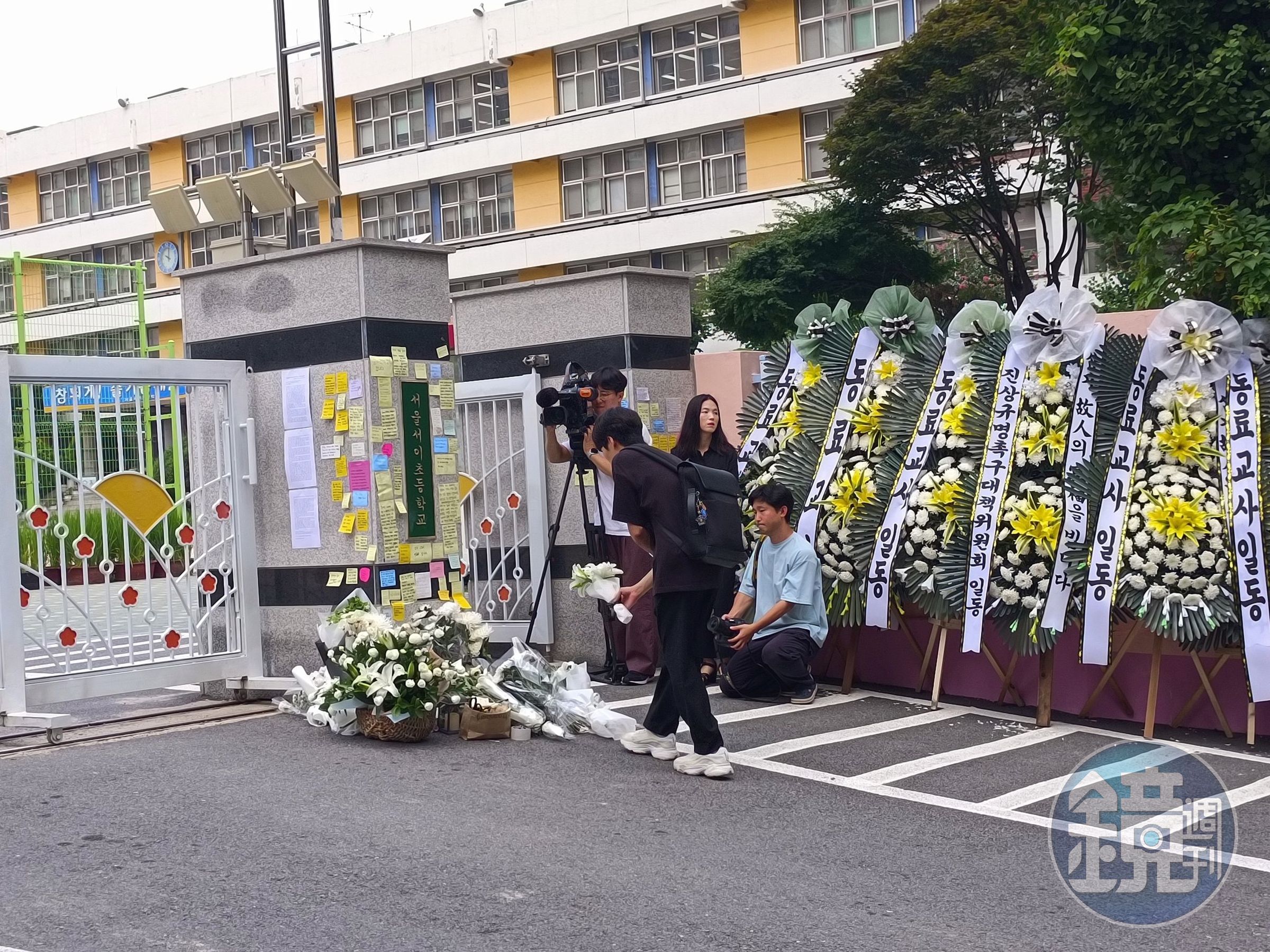 首爾一名小學女老師疑遭家長霸凌導致輕生，不少民眾在校門獻花哀悼。（翻攝推特@koryodynasty）