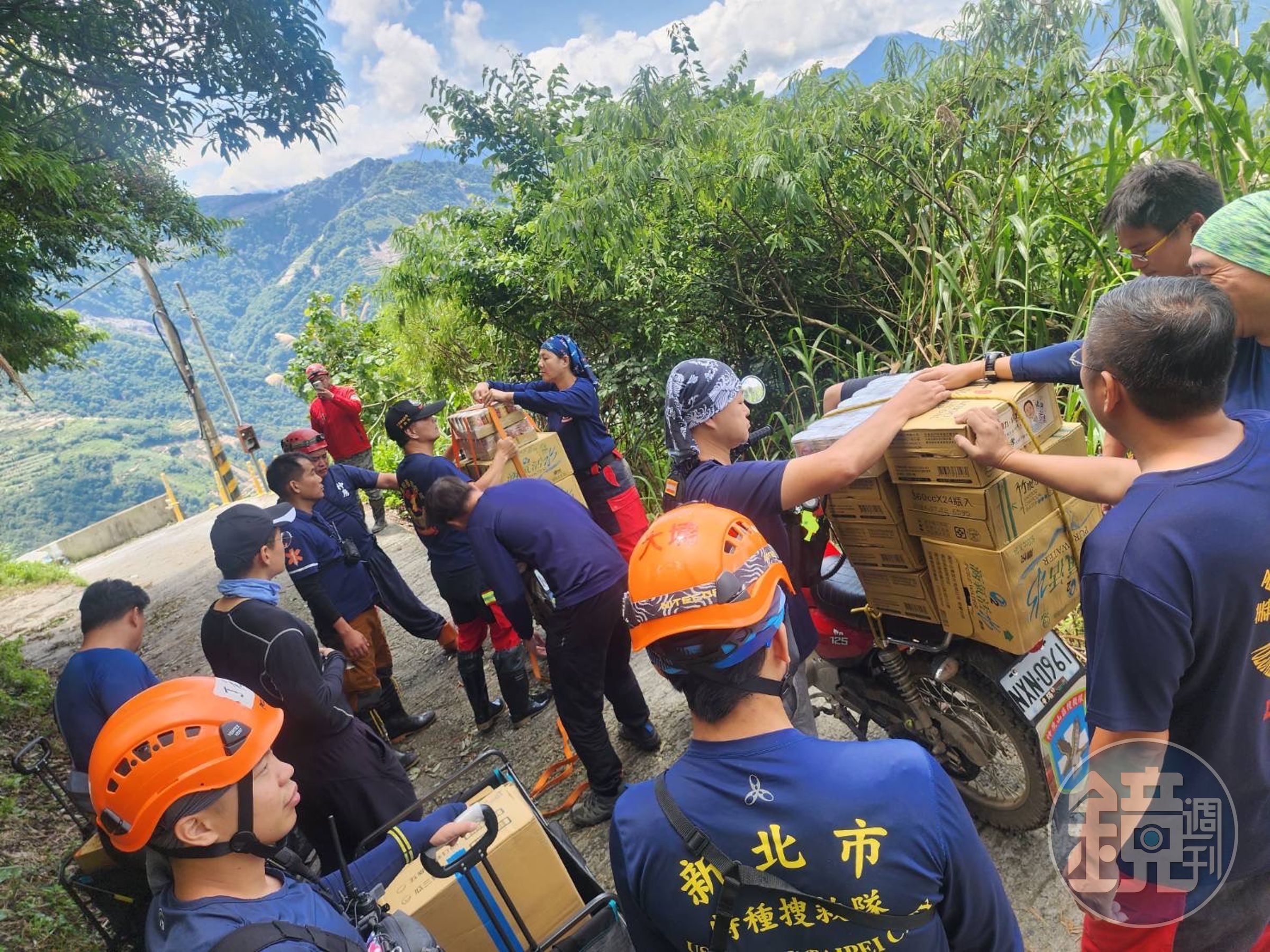 因道路通行受阻，搜救團隊只能透過徒手攀爬，靠近受困地點，以人力接龍搬進物資。（翻攝自新北消防發爾麵）