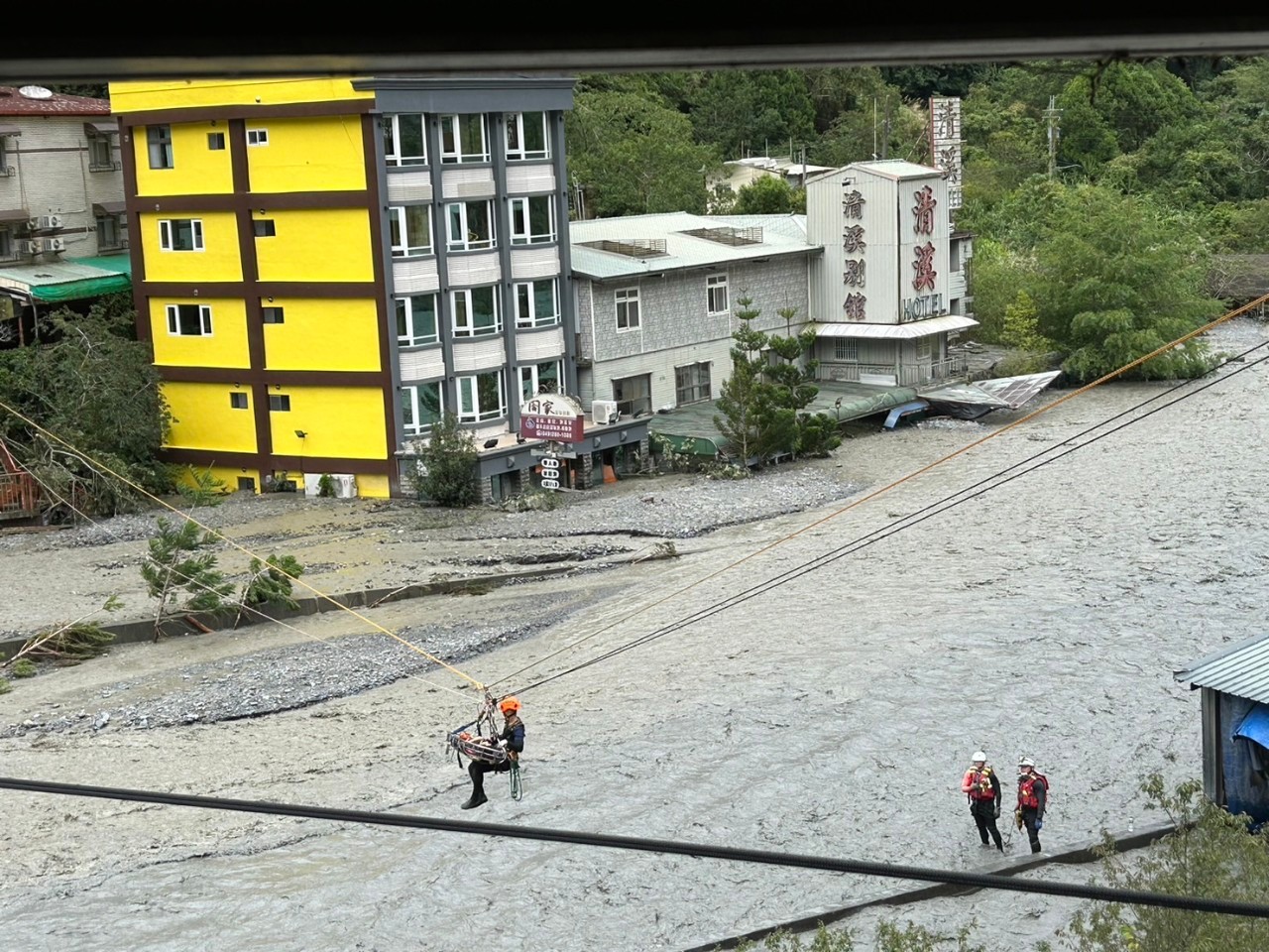 搜救人員以繩索橫渡的方式將受困民眾撤離。（消防署提供）