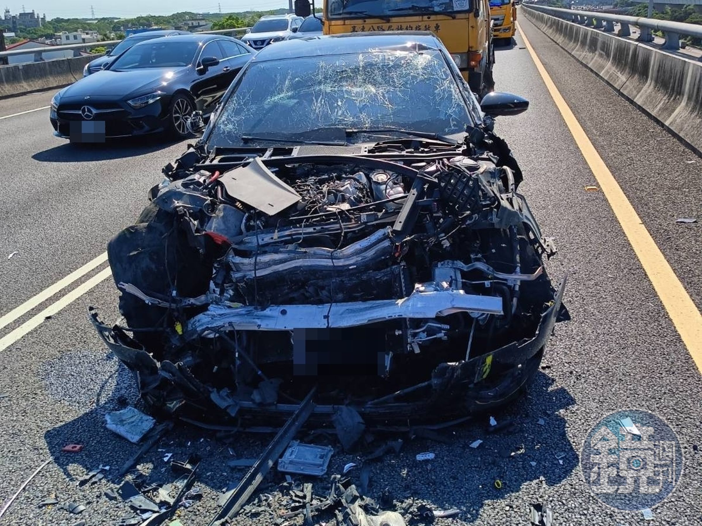 肇事的黑色轎車車頭幾乎全毀，零件碎片散落一地。（翻攝畫面）