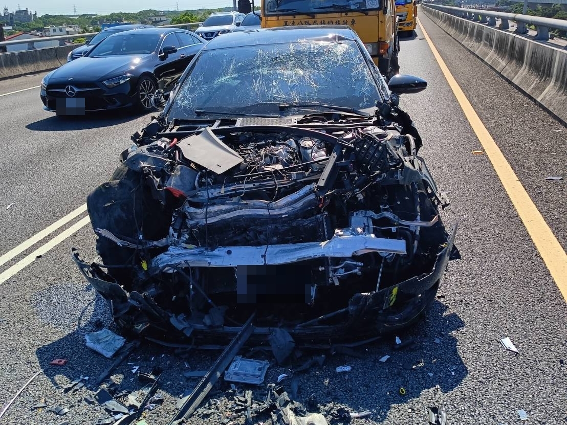 肇事的黑色轎車車頭幾乎全毀，零件碎片散落一地。（翻攝畫面）